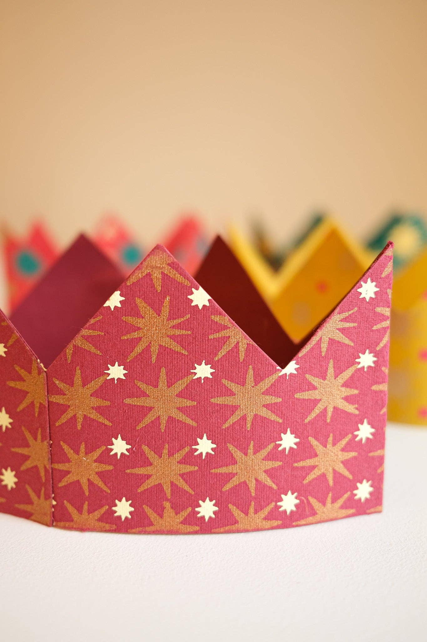 Decorative paper crown with star pattern on a plain background.