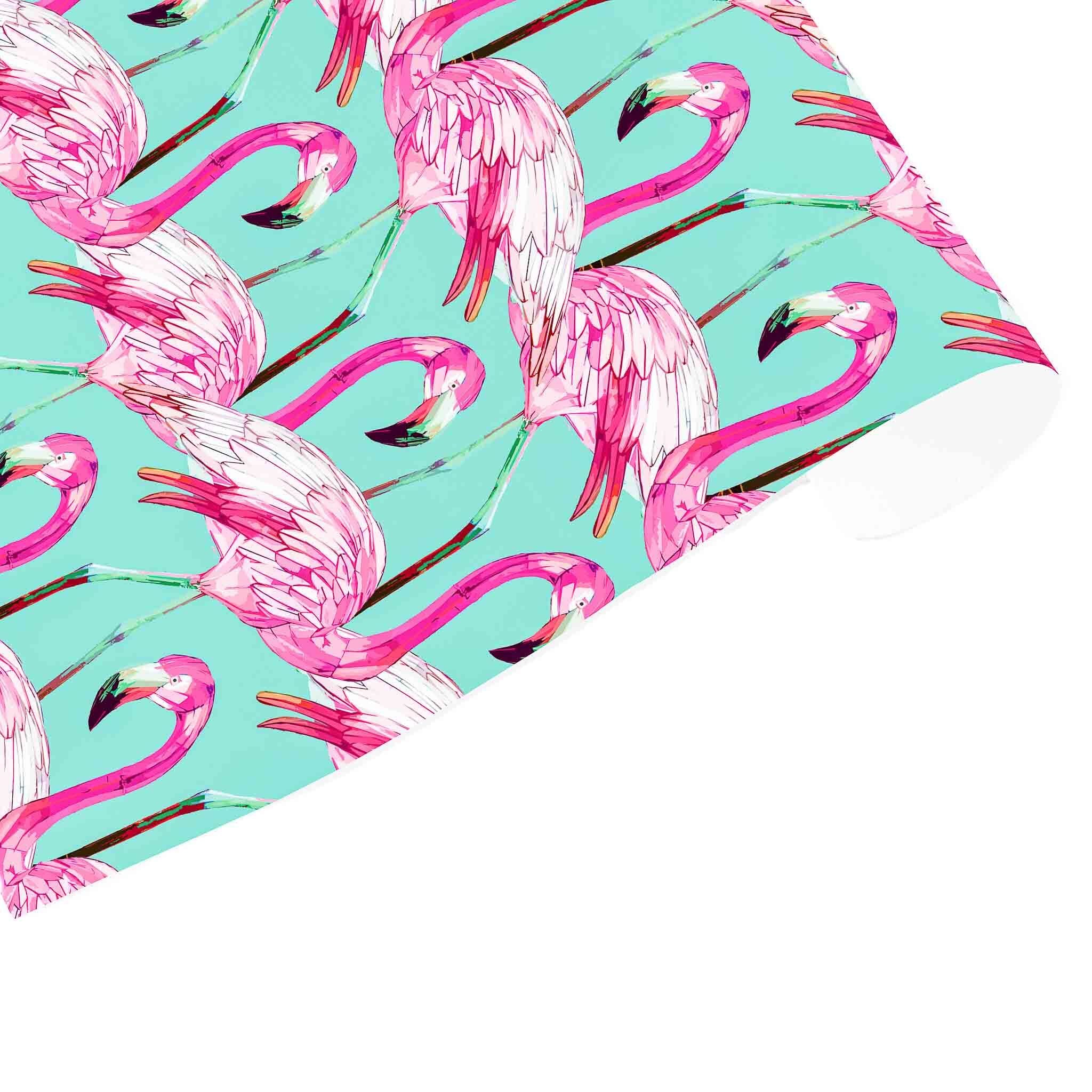 A sheet of green wrapping paper with a pattern of pink flamingos.