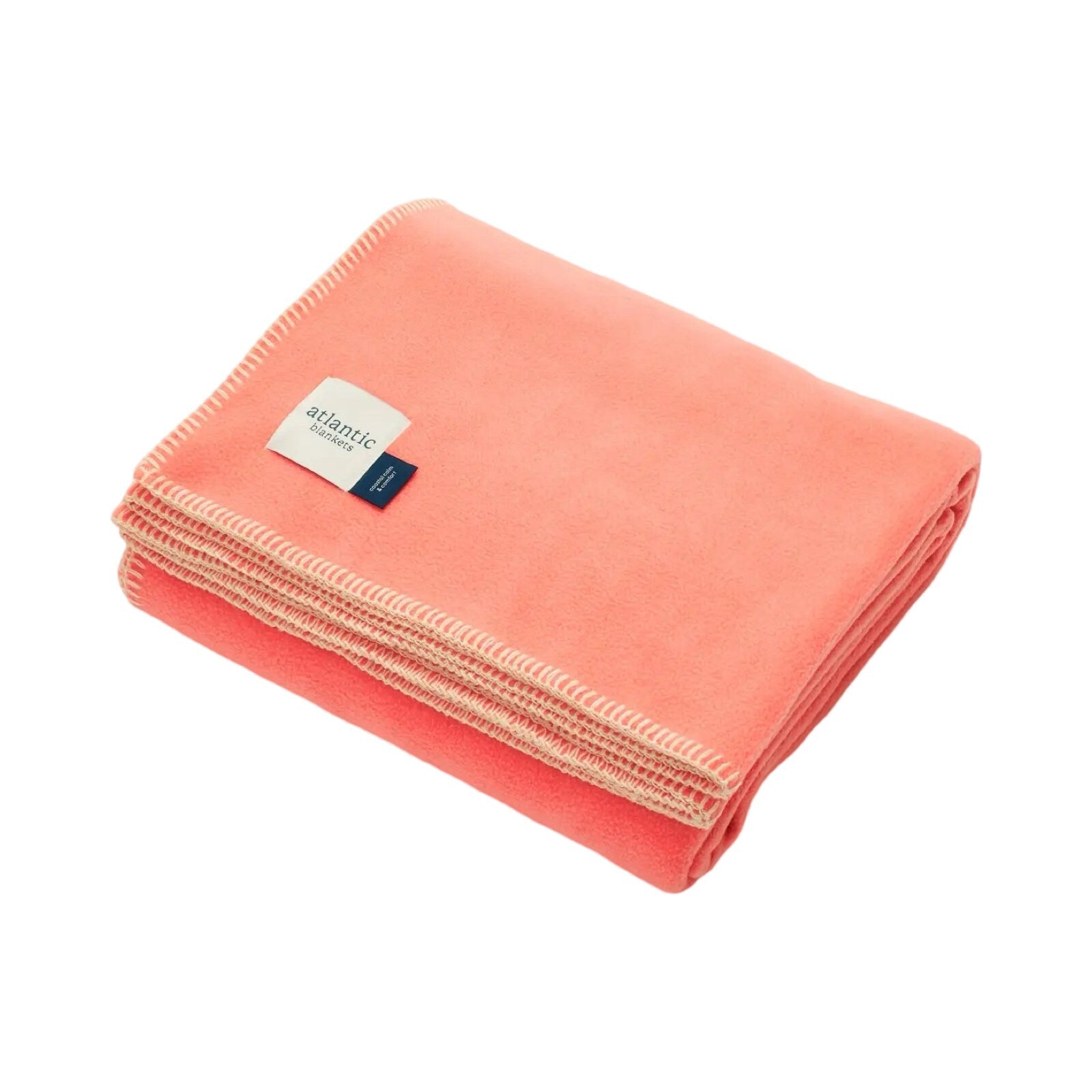 A coral fleece blanket with cream stitched edges.