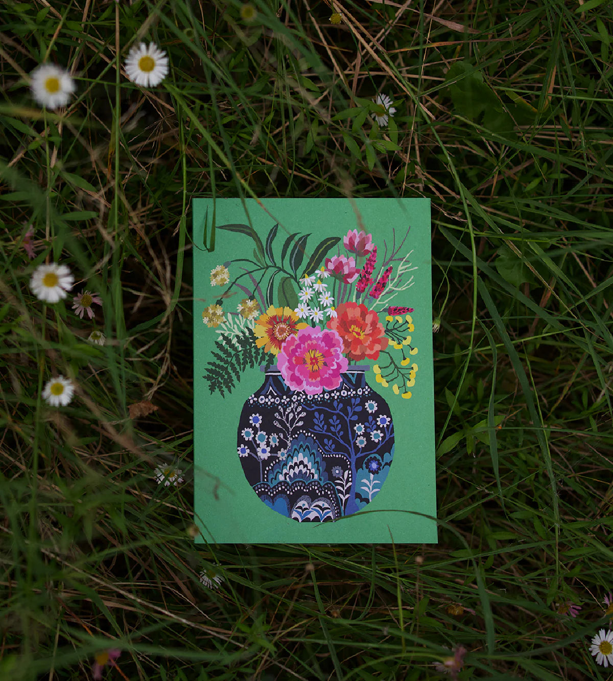 Card with green floral design on a grassy background.