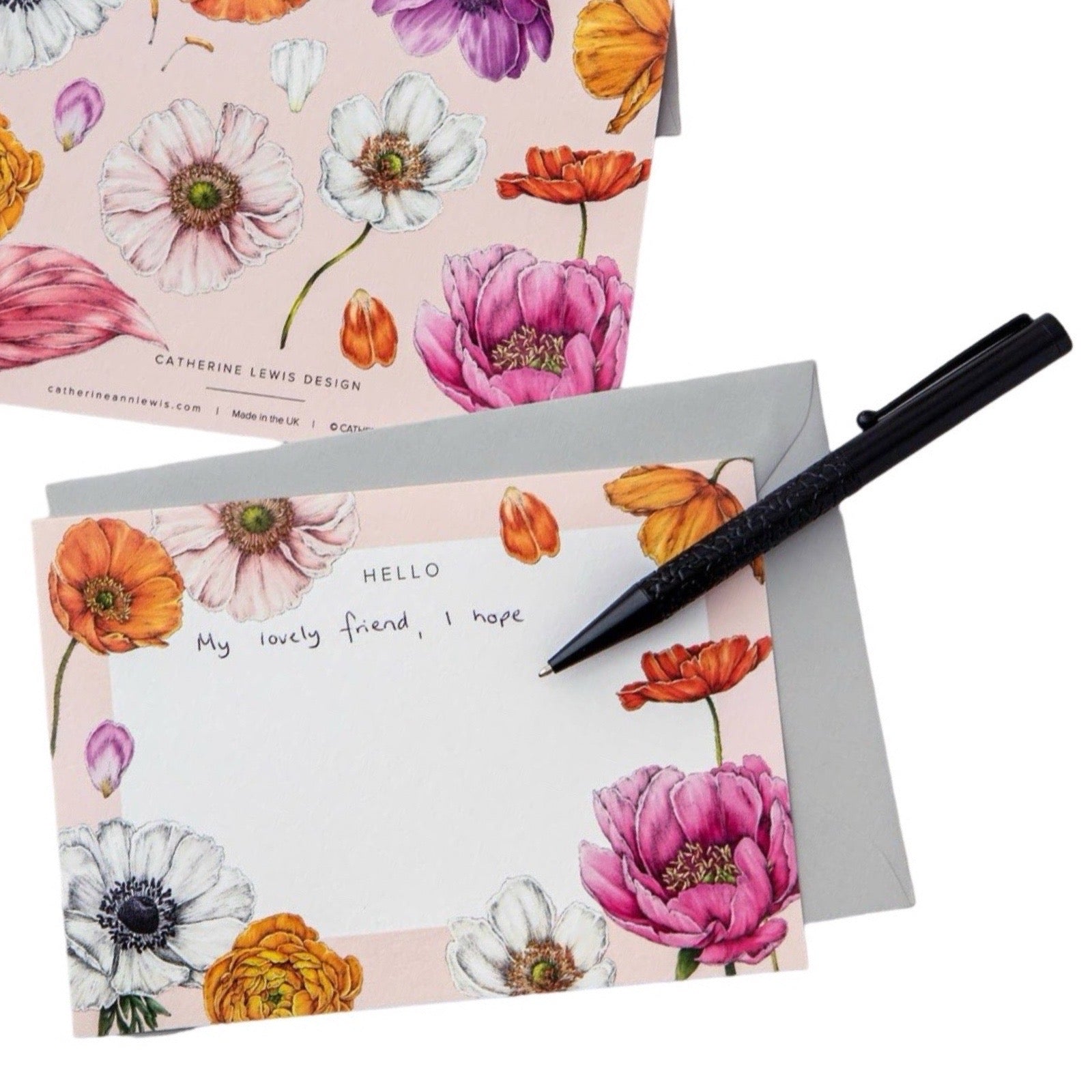 Floral notepad with an envelope and a pen.