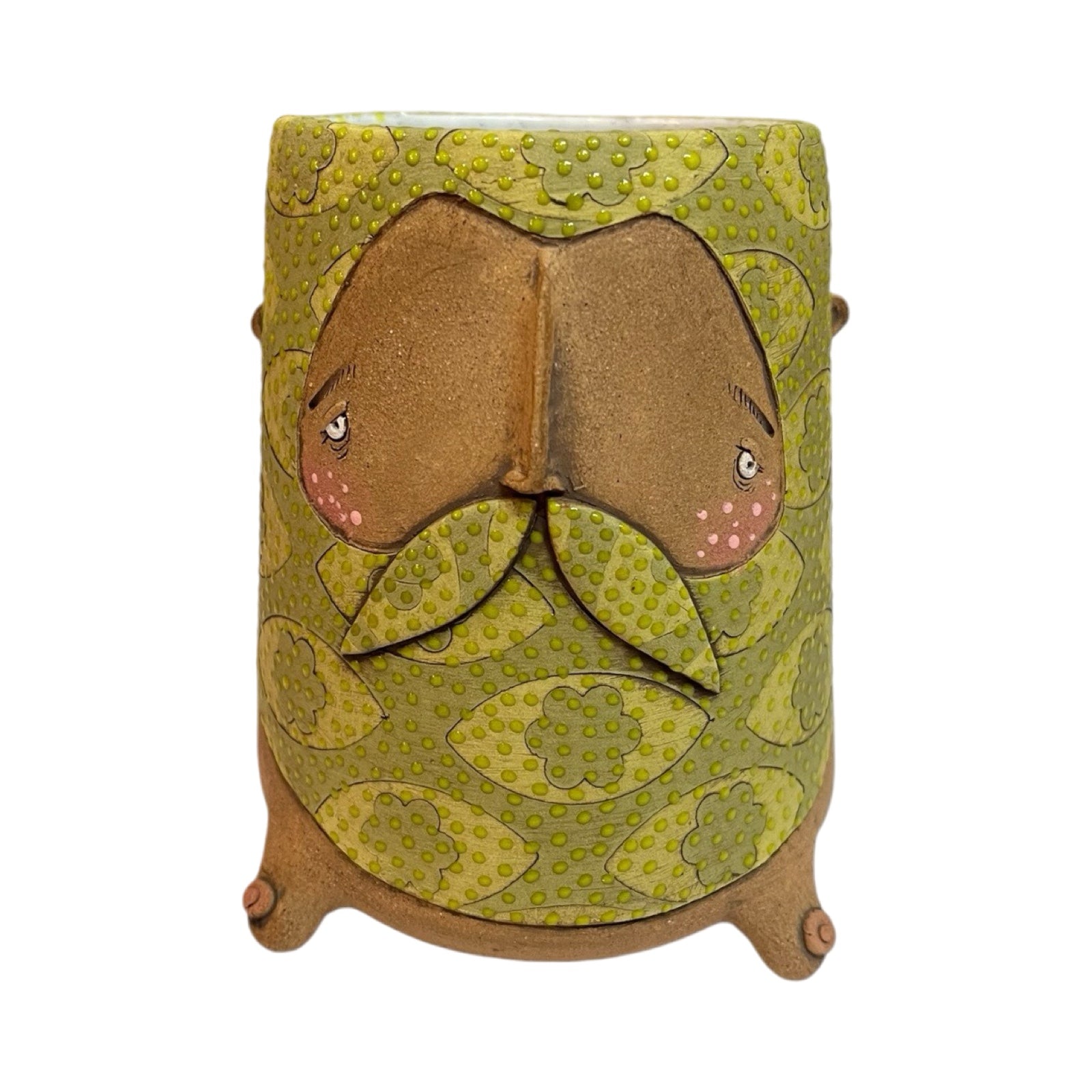 A ceramic beaker with a male moustached face and a green floral pattern.
