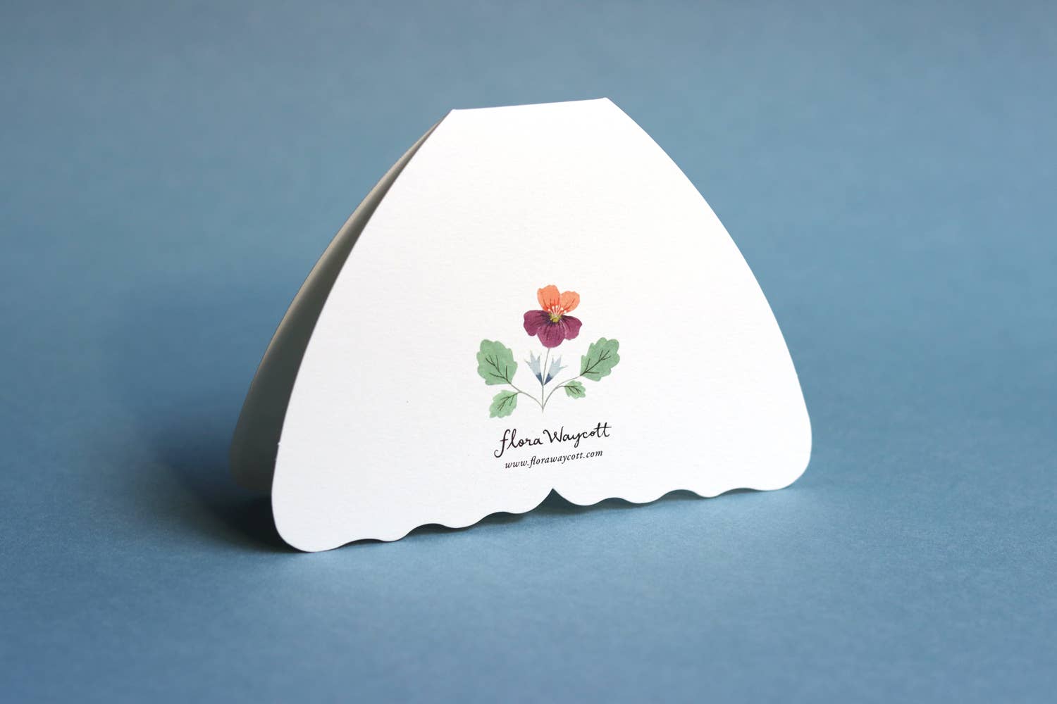Back of moth card with floral design and text on a blue background.