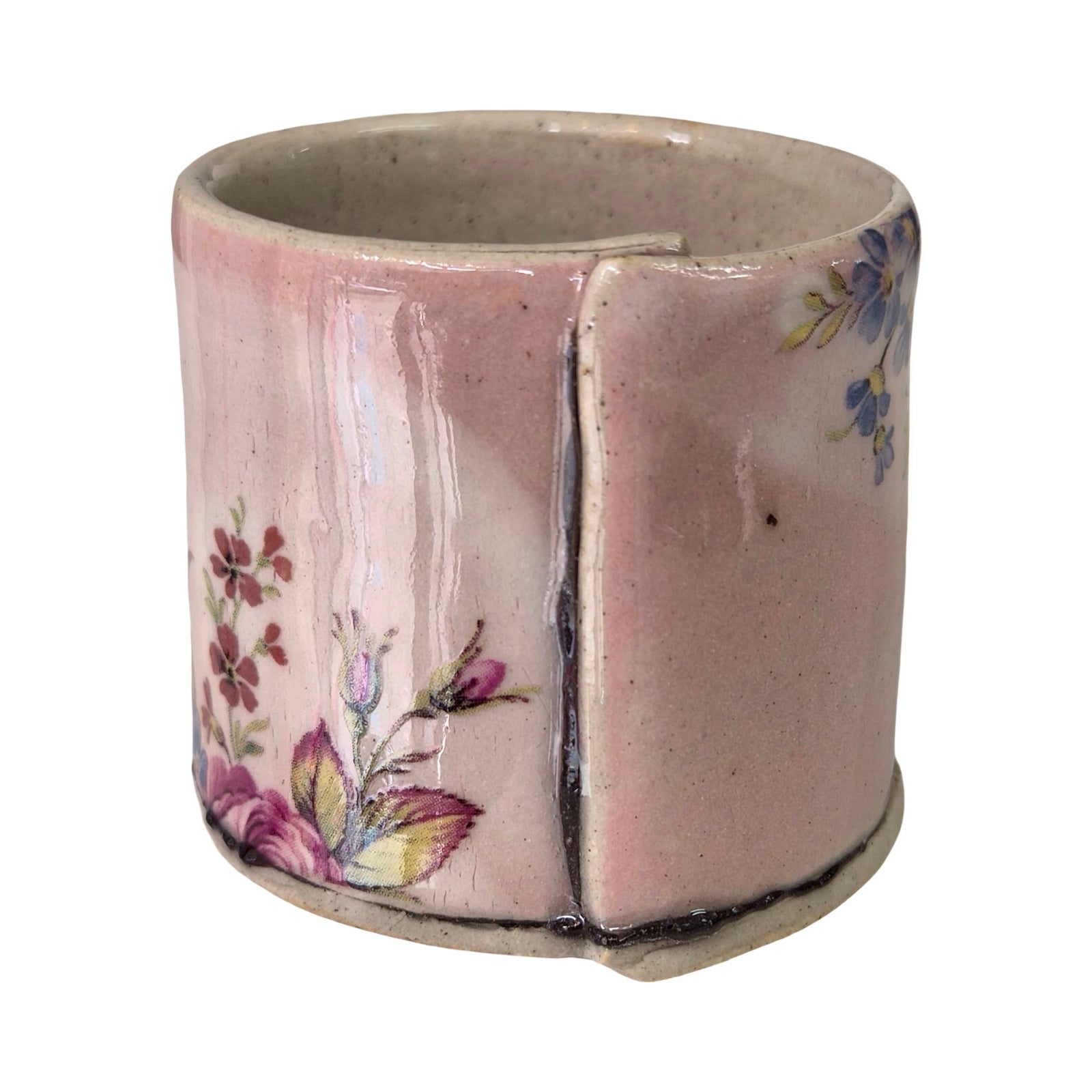 Ceramic planter with floral design on a pink background.