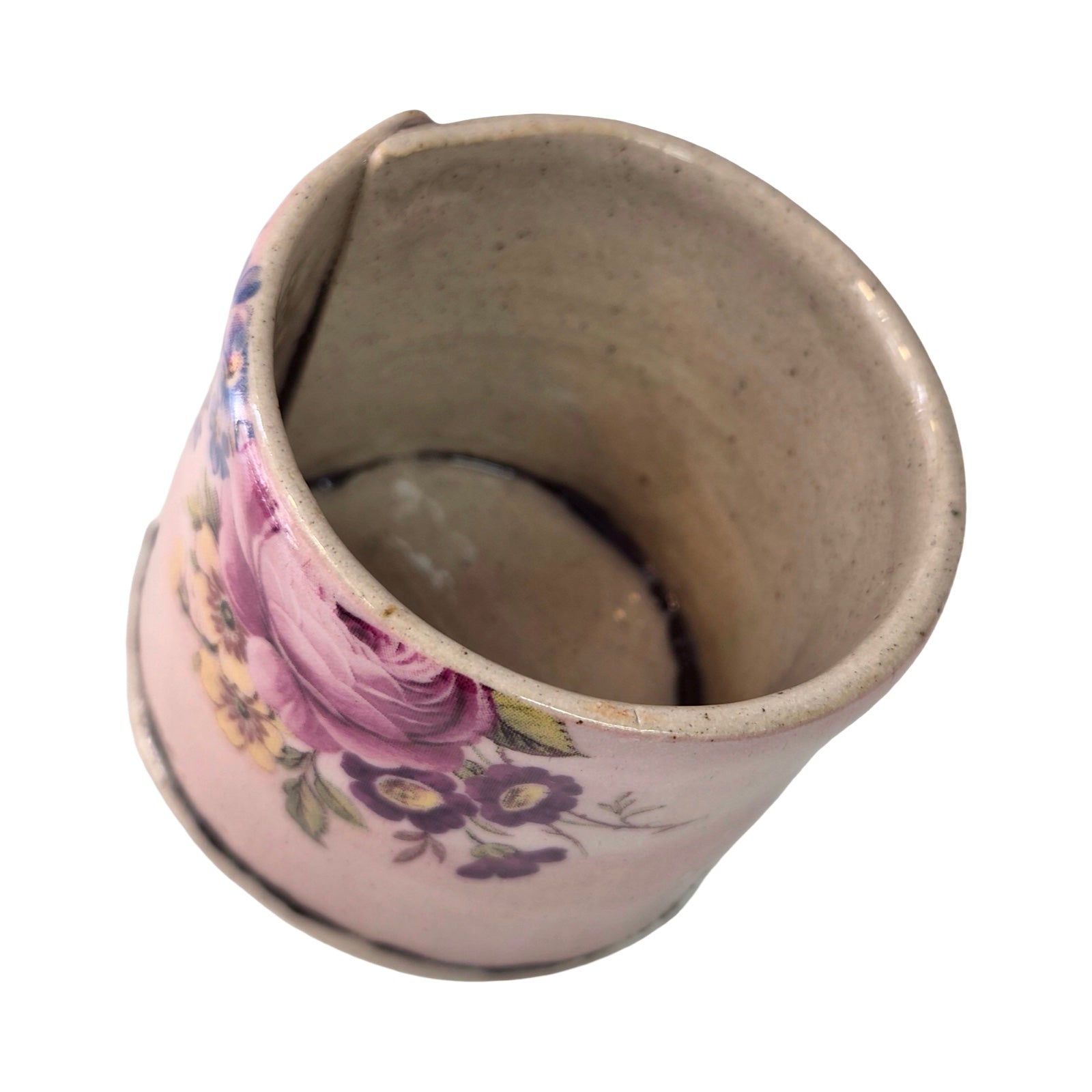Ceramic planter with floral design on a pink background.