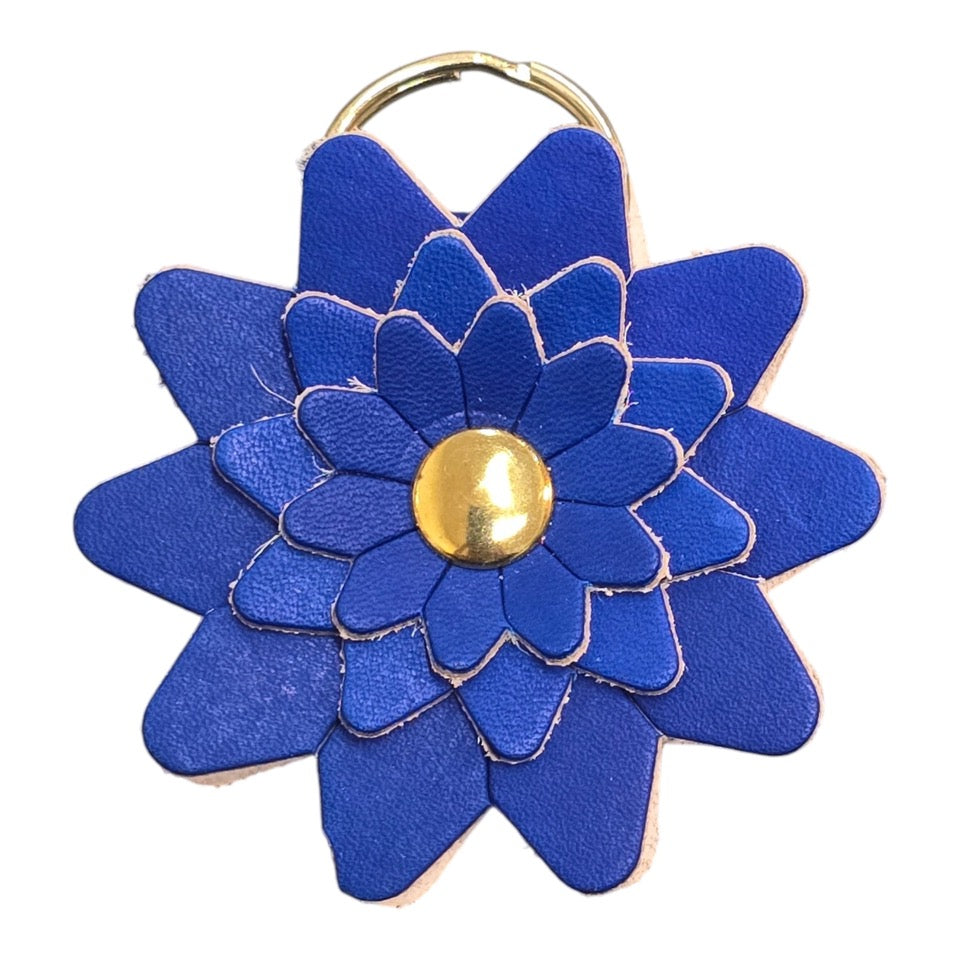 Blue leather flower-shaped keyring with a gold rivet and gold ring.