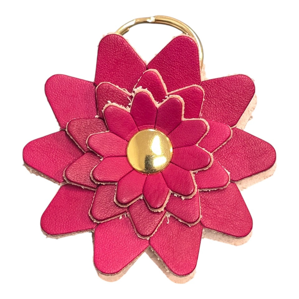 Red leather flower-shaped keyring with a gold rivet and gold ring.