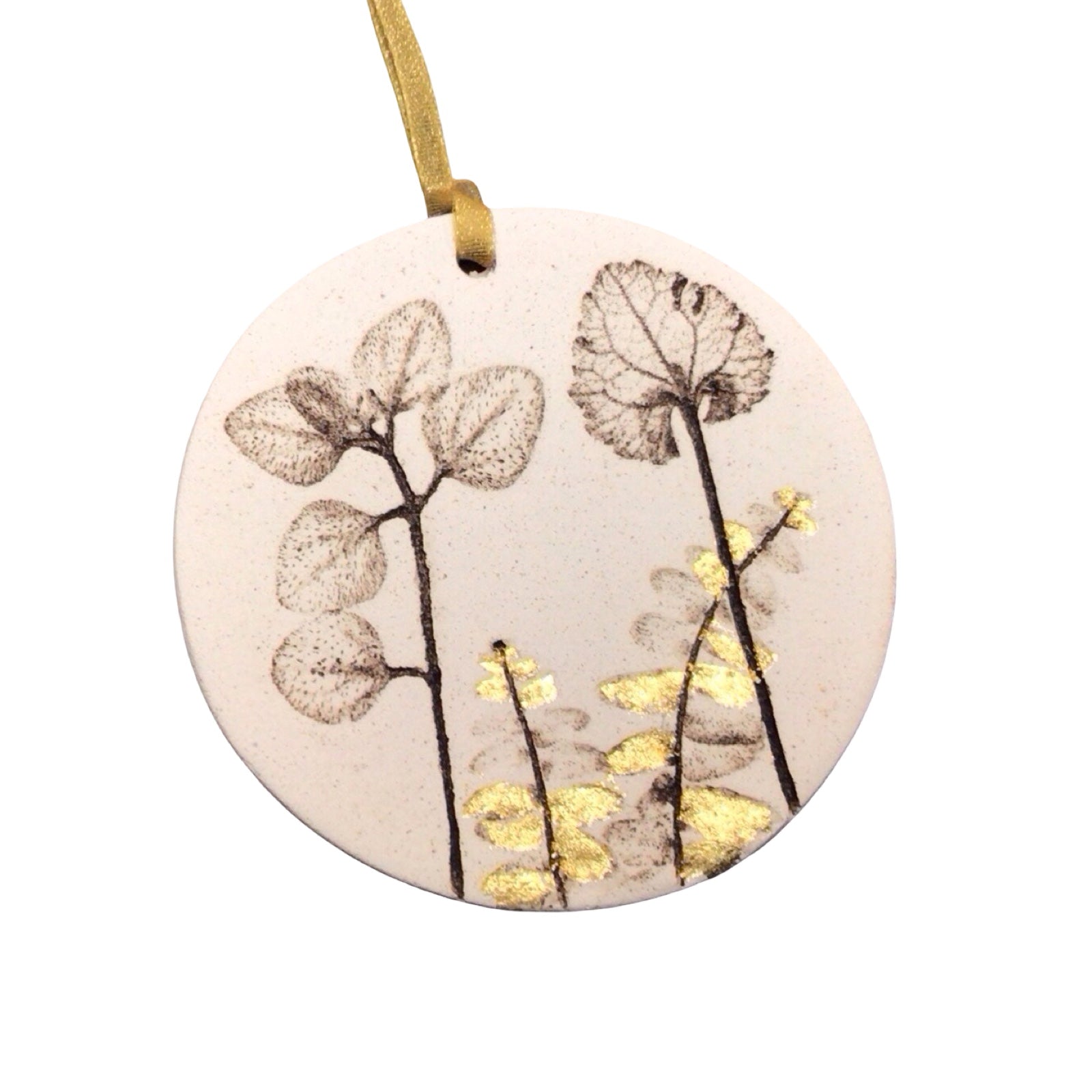 Round ceramic ornament with floral design and gold accents on a white background