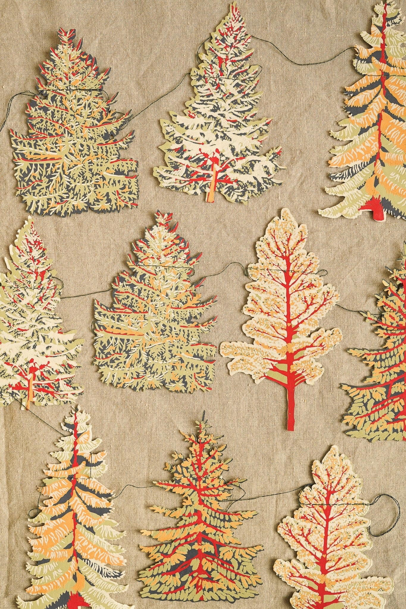Decorative paper cutout trees on a textured beige background.