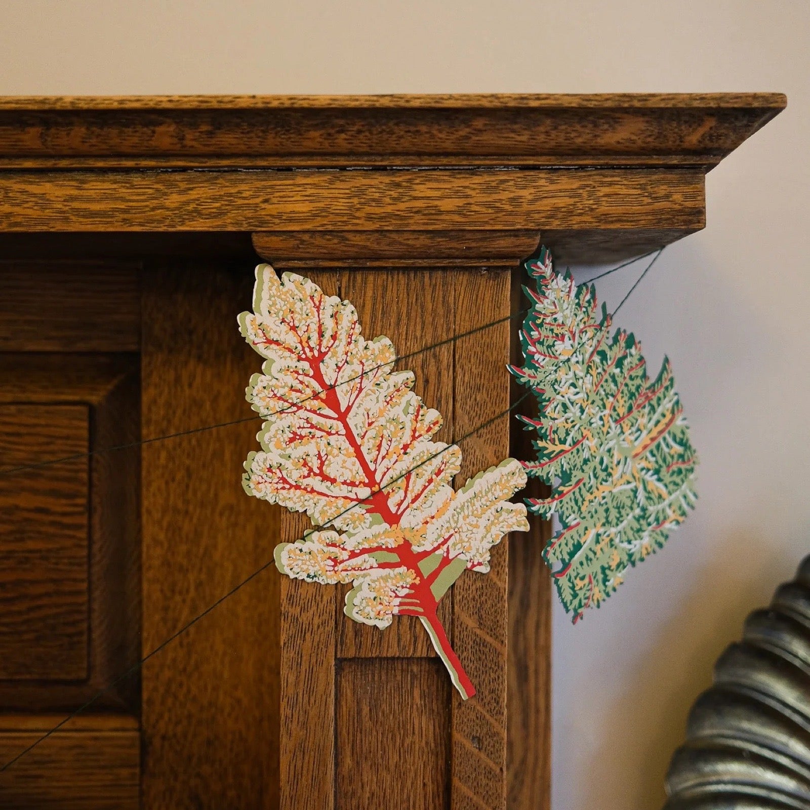 Decorative Christmas tree garland on a wooden surface with a neutral background.