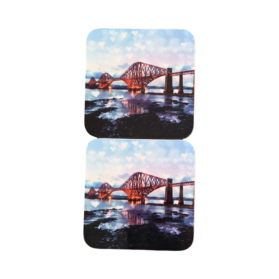 Two coasters with a scenic design of a bridge over water on a white background