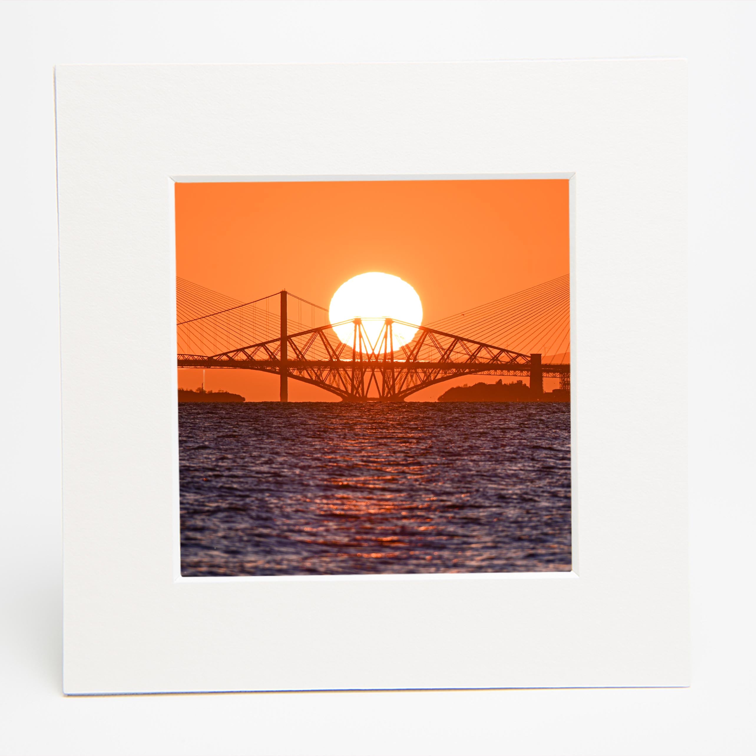 An image of the three bridges over the Forth with the sun setting behind them in square mount. 