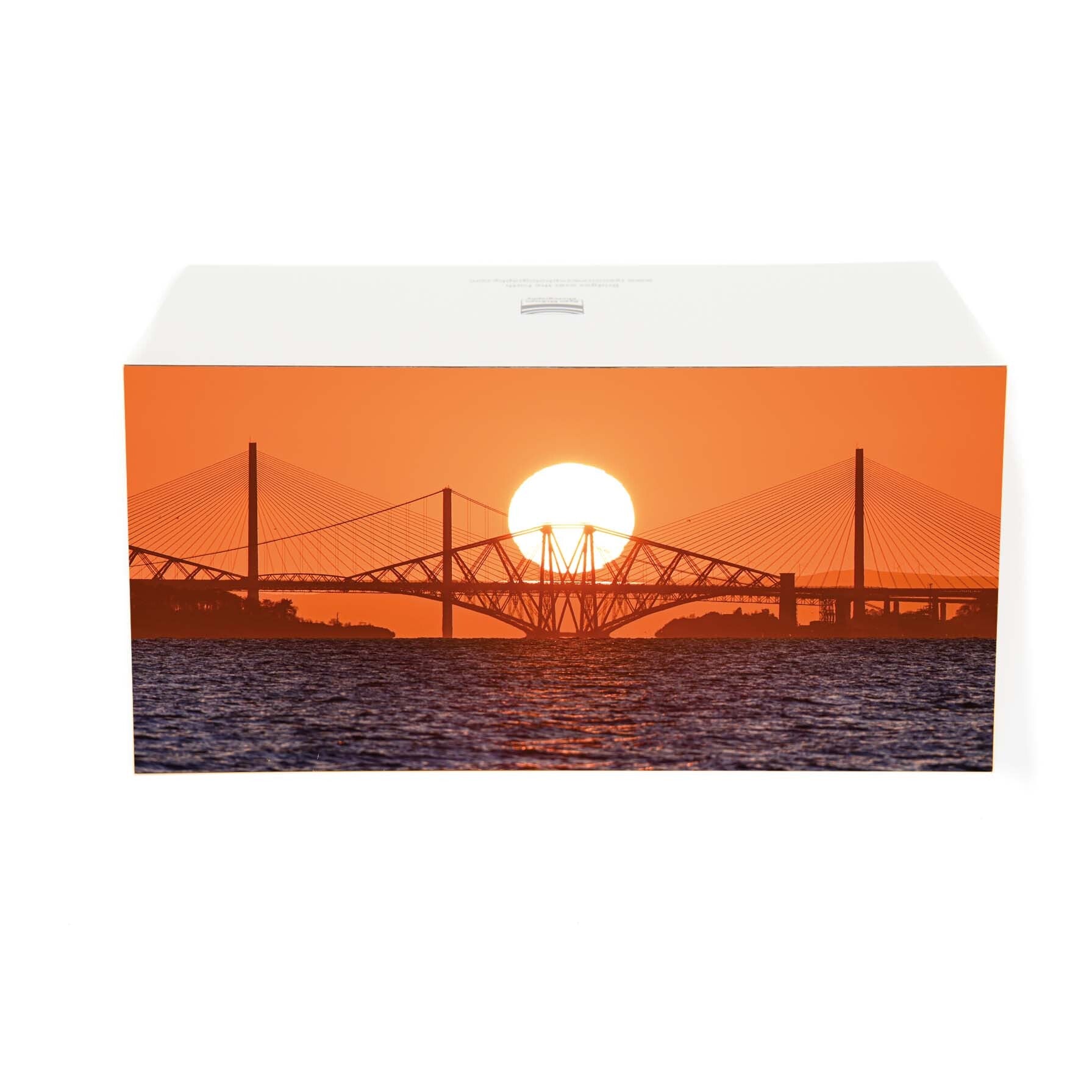 The sunset behind the three bridges of the Forth on a card. 