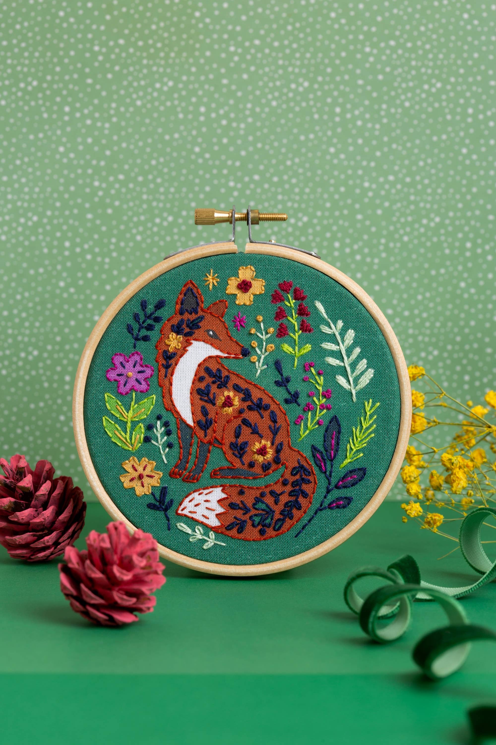 Embroidery hoop with a fox design on a green background.