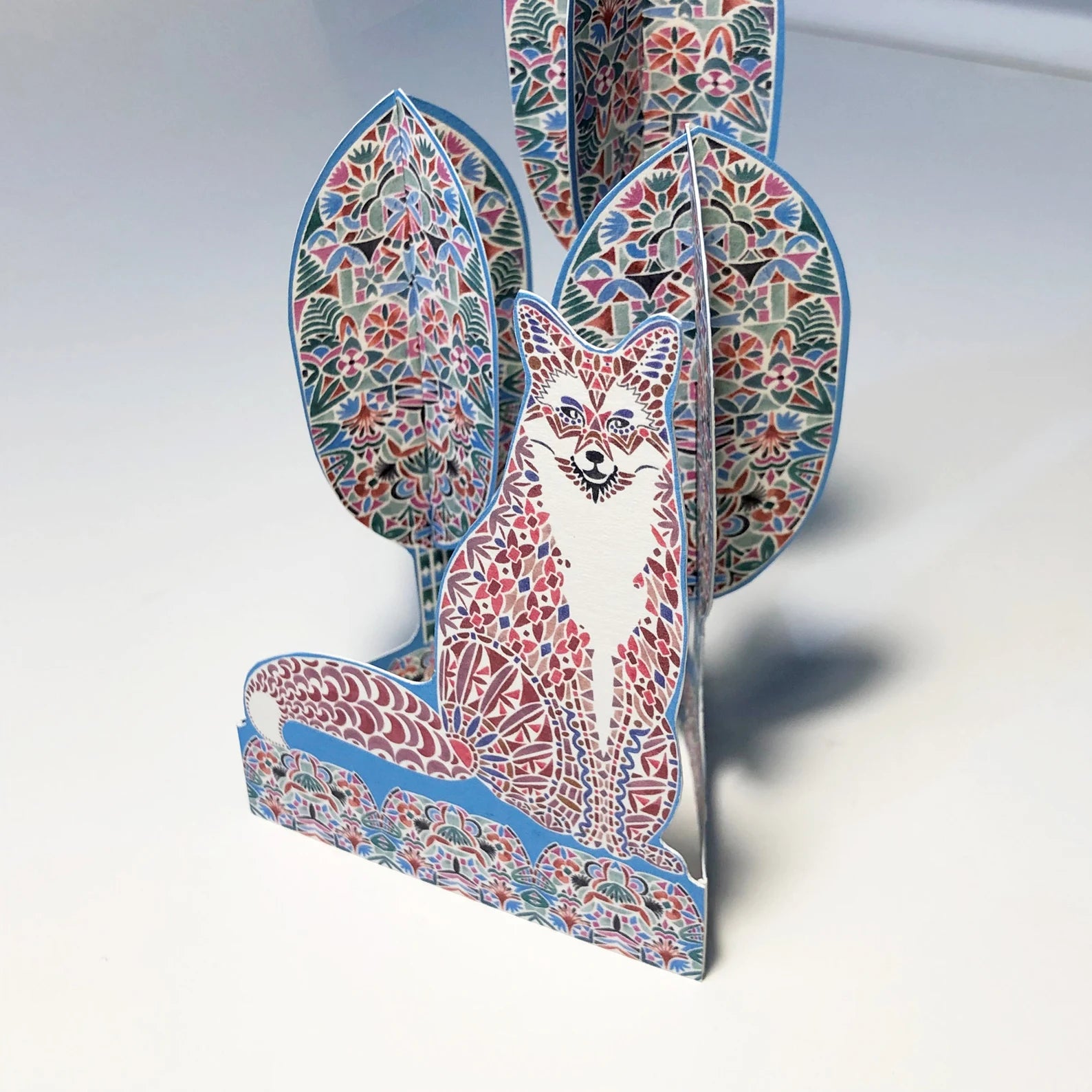 Colourful fox-shaped card with intricate patterns on a white background.