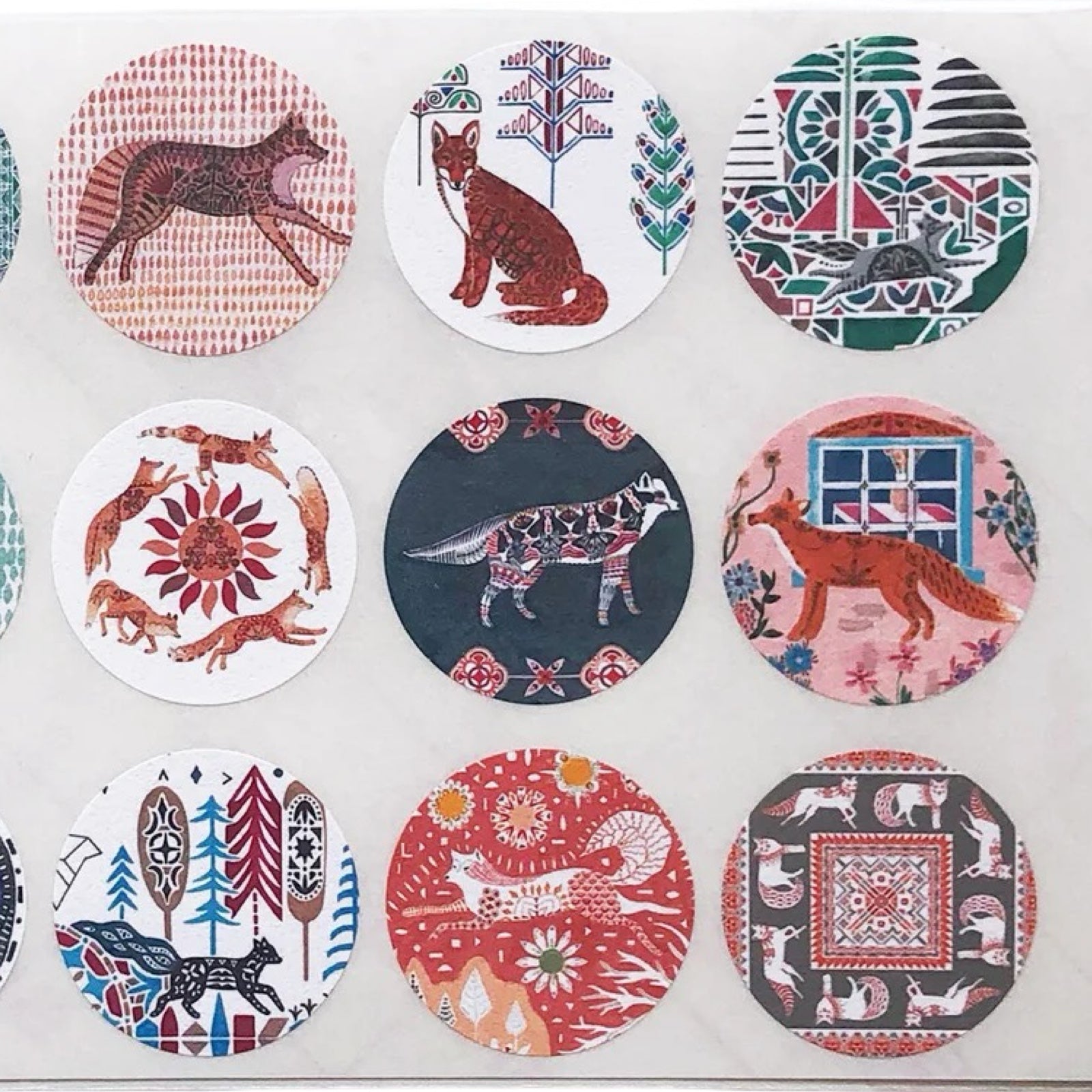 Set of circular stickers with fox-themed designs on a white background.