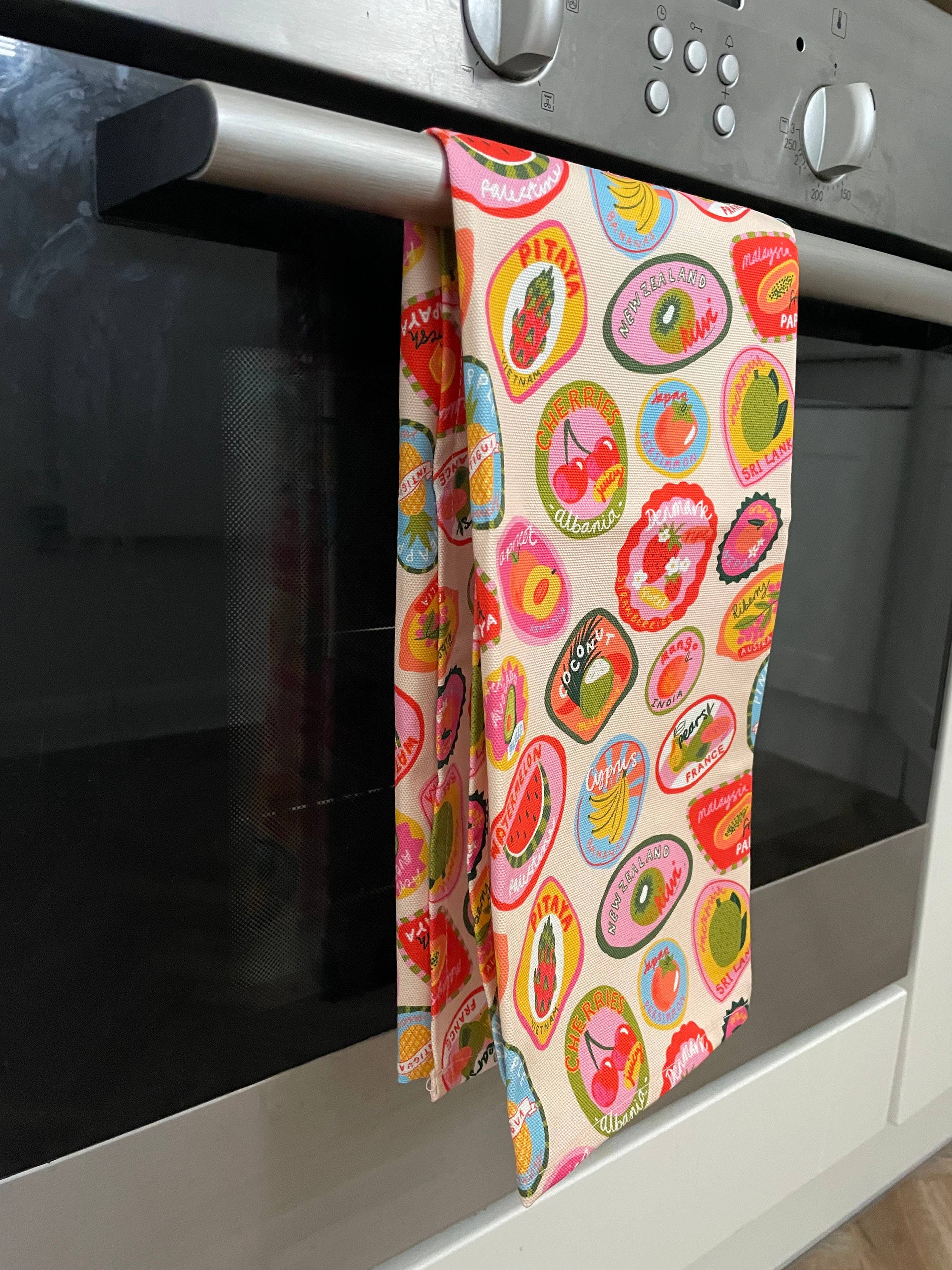 Colorful patterned towel hanging from an oven handle.
