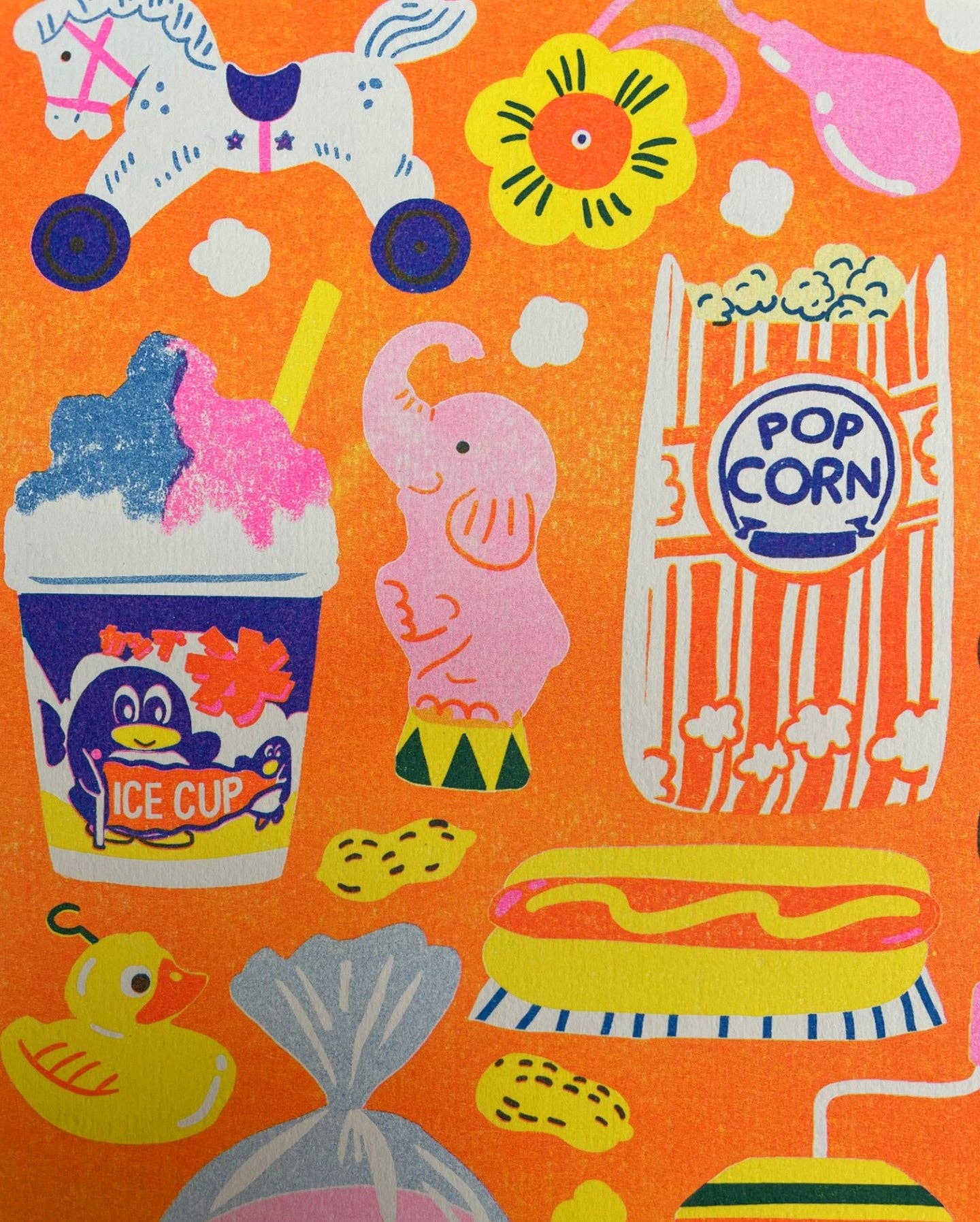 Colourful fabric with illustrations of ice cream, popcorn, and other snacks on an orange background.