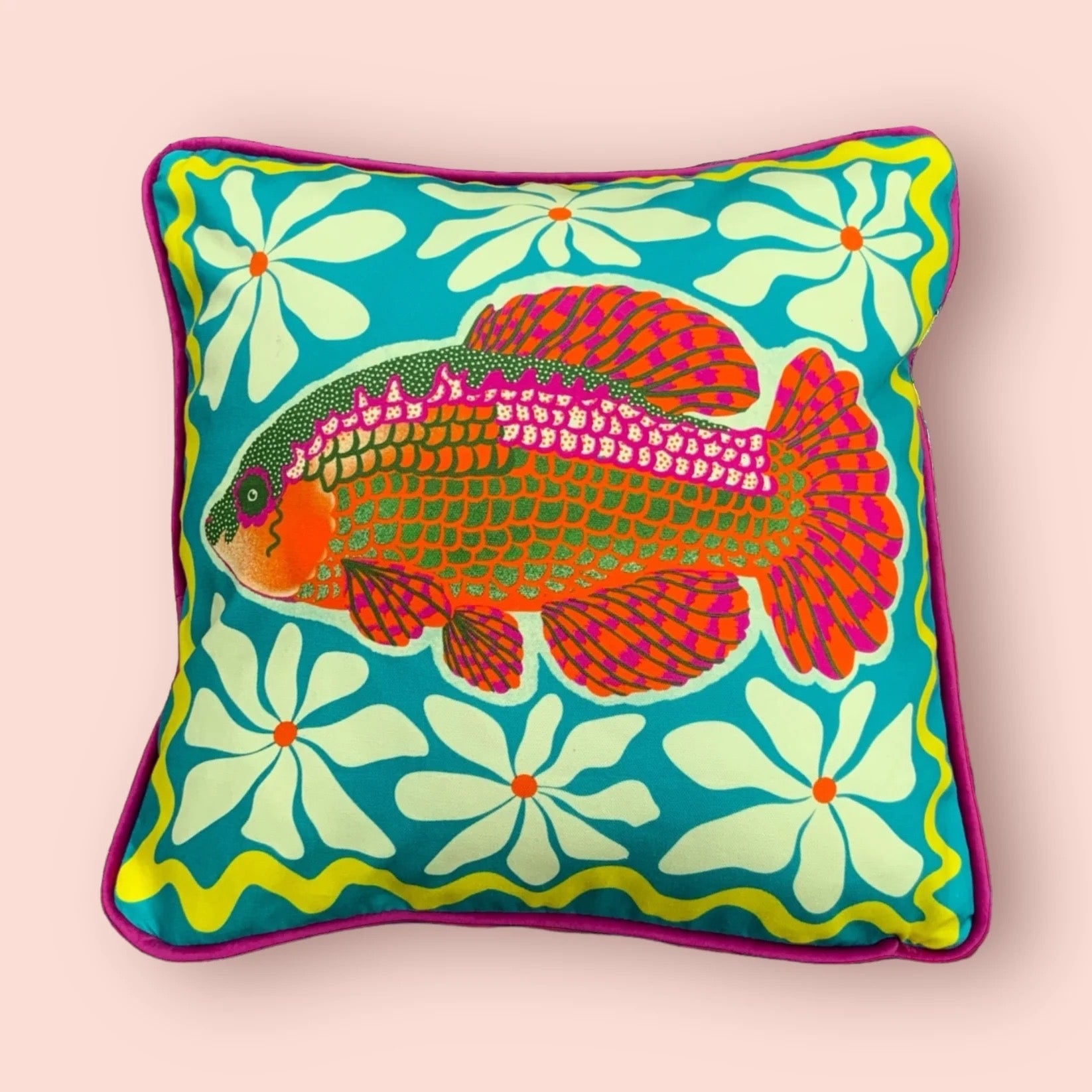 Decorative cushion with a fish design on a floral background.