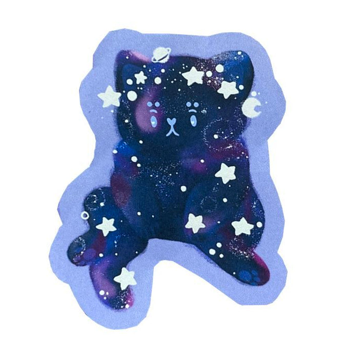 Handmade sticker of a galaxy patterned cat, sitting upright and looking existential. 