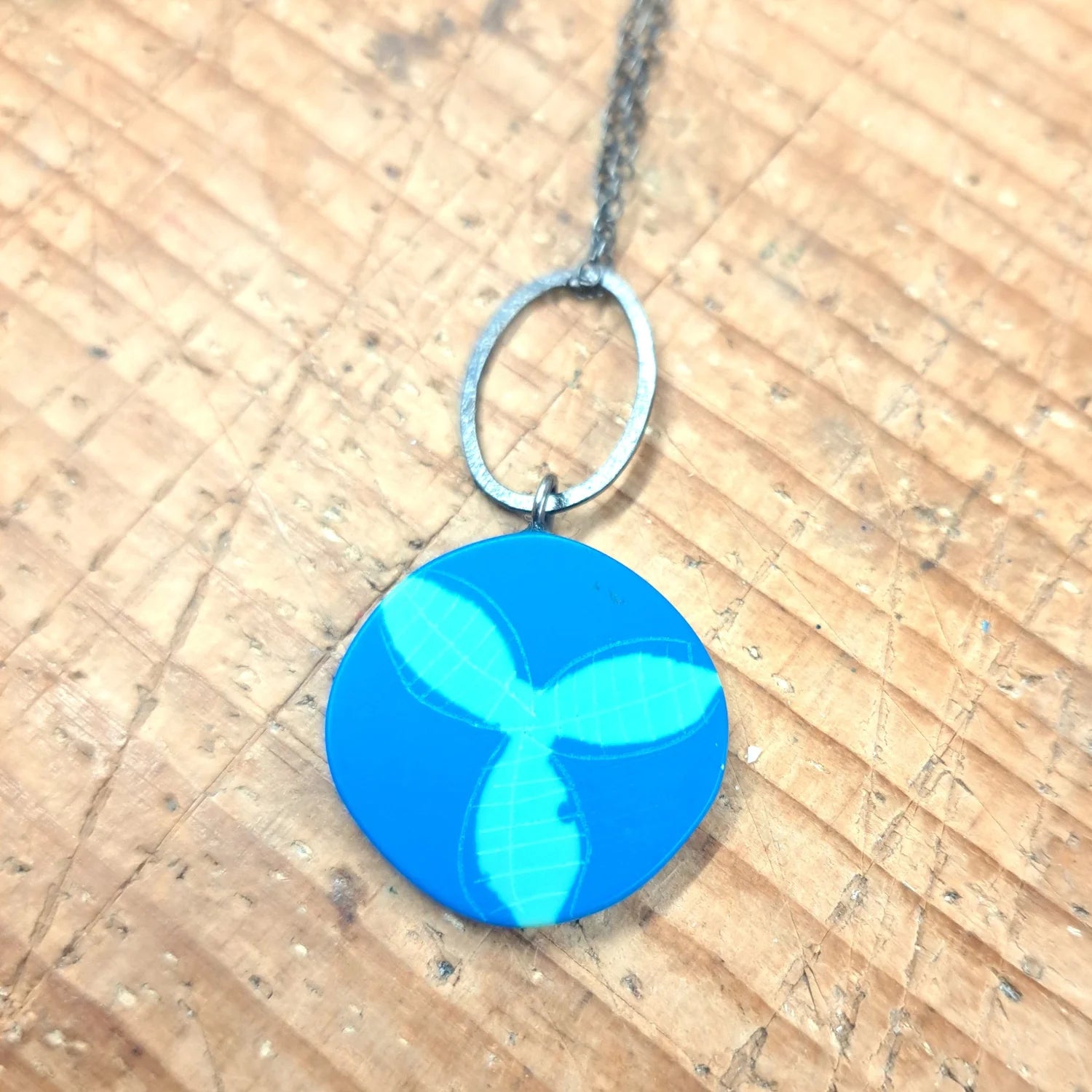 Blue pendant necklace on a wooden surface.