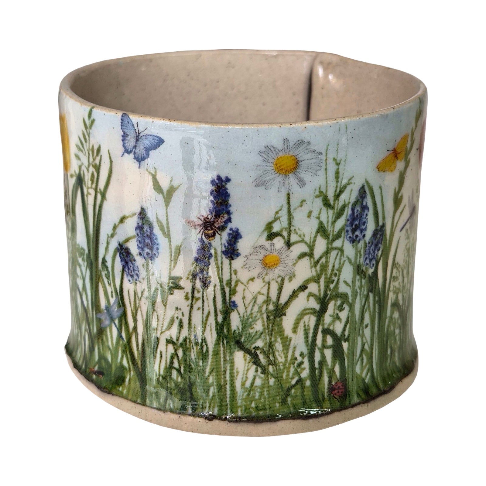 Ceramic mug with nature-themed design of flowers and butterflies on a white background.