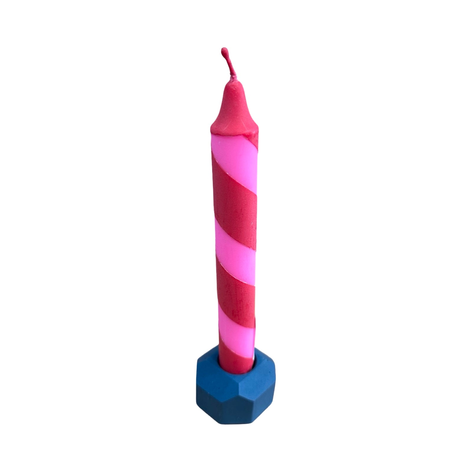 A small geometric shaped dinner candle holder in navy holding a pink and red candy striped dinner candle.