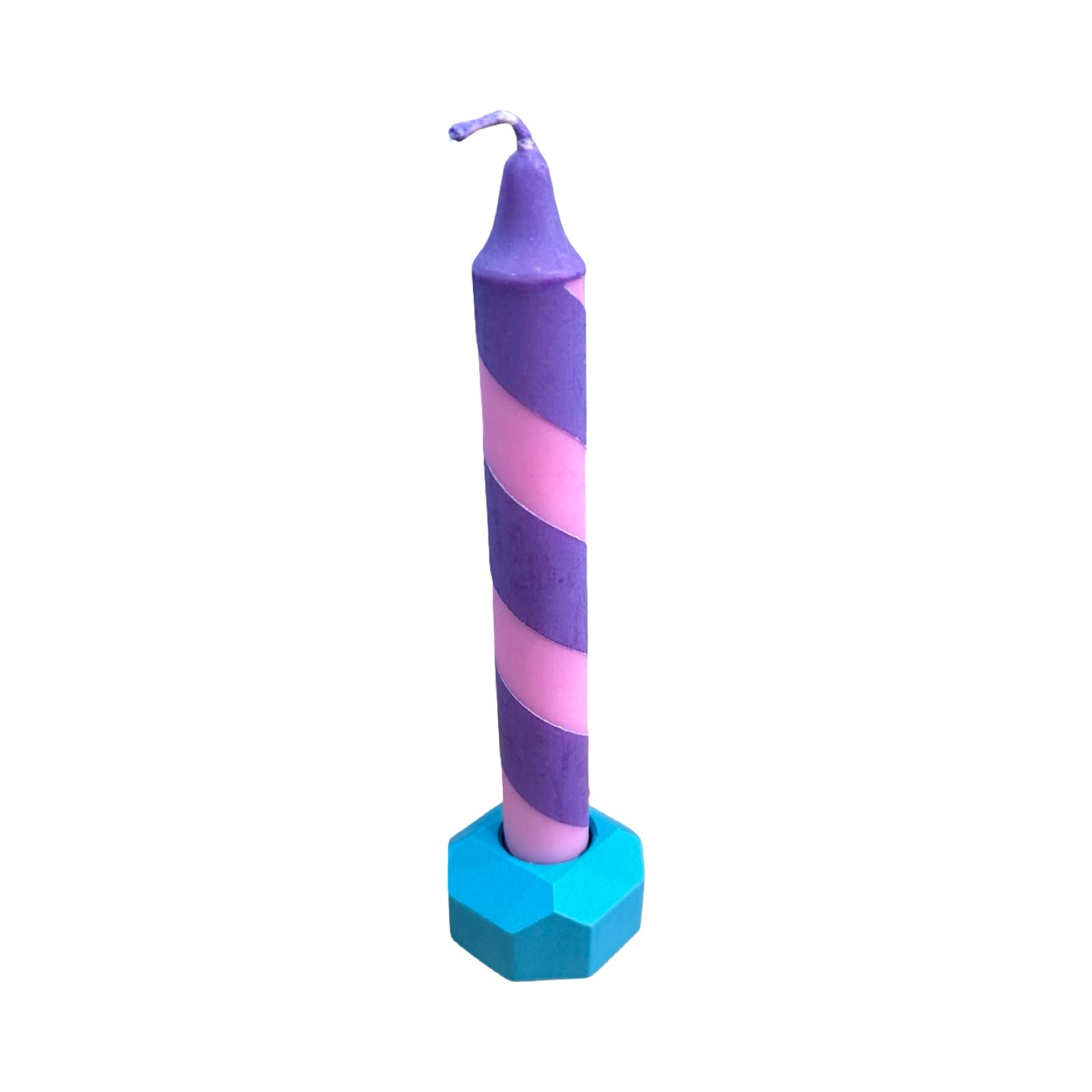 A small geometric shaped dinner candle holder in turquoise holding a pink and purple candy striped dinner candle.
