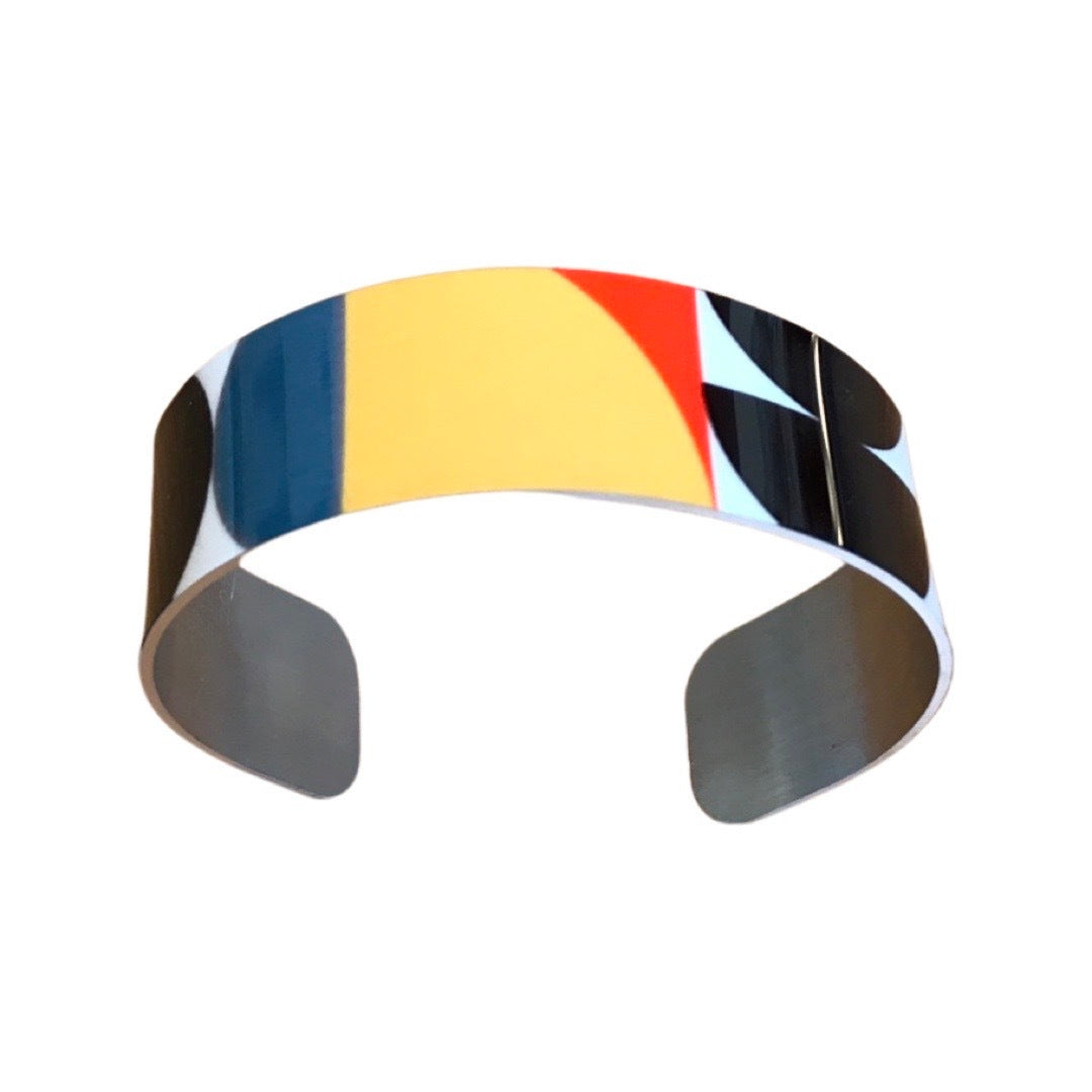 Top of a narrow cuff bracelet featuring a geometric multicoloured design.