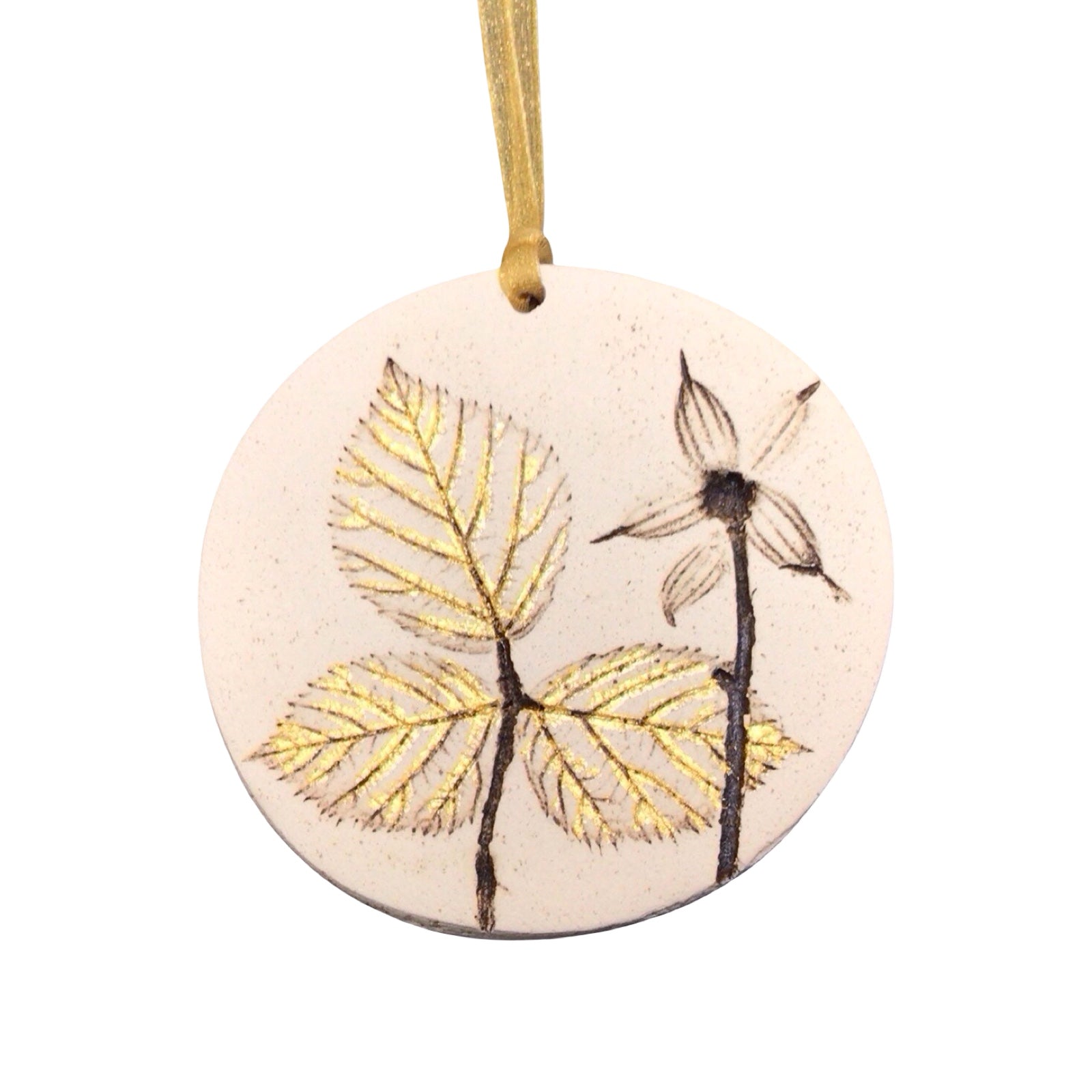 Round ceramic ornament with leaf design on a white background