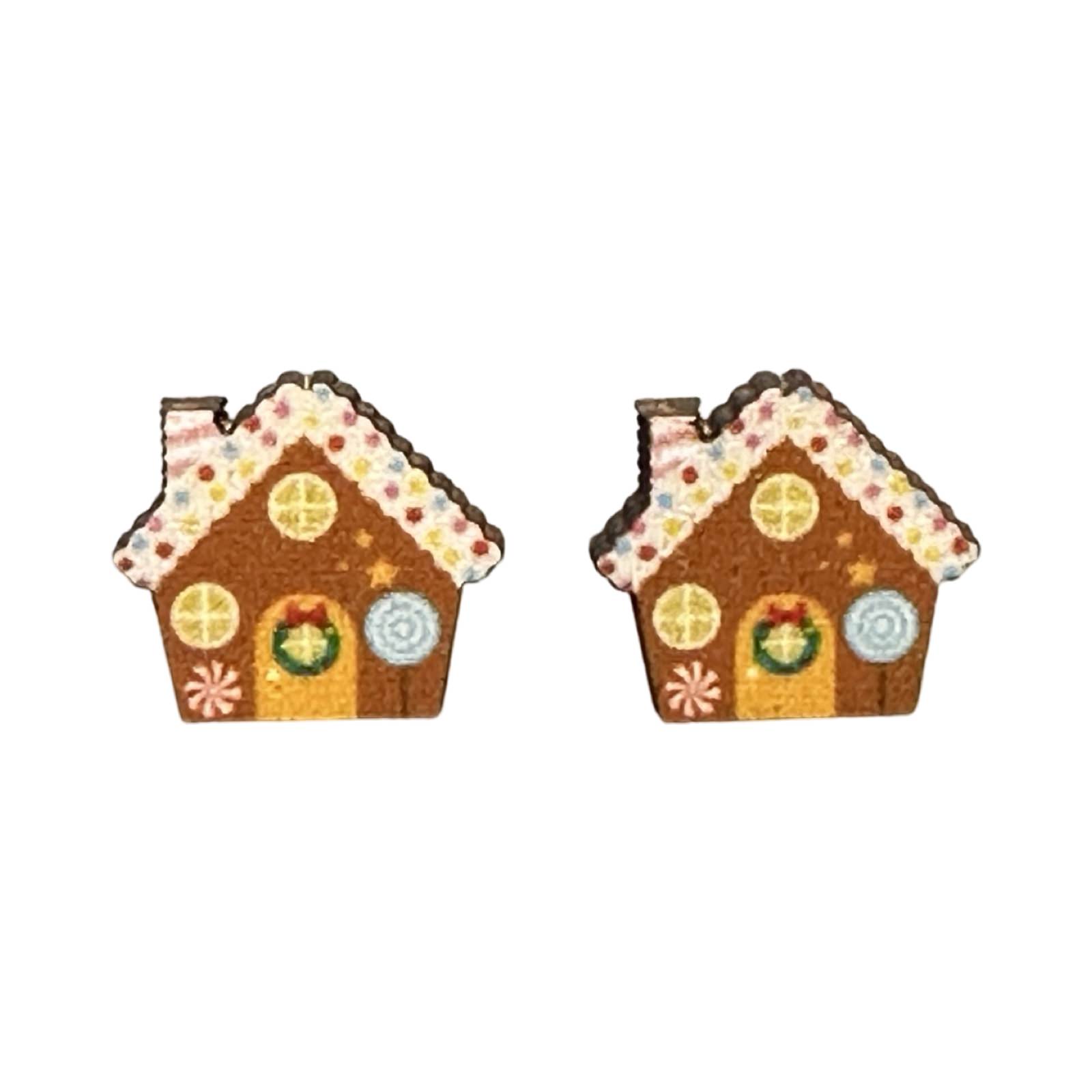 A pair of wooden stud earrings shaped like a gingerbread house with decorative house.