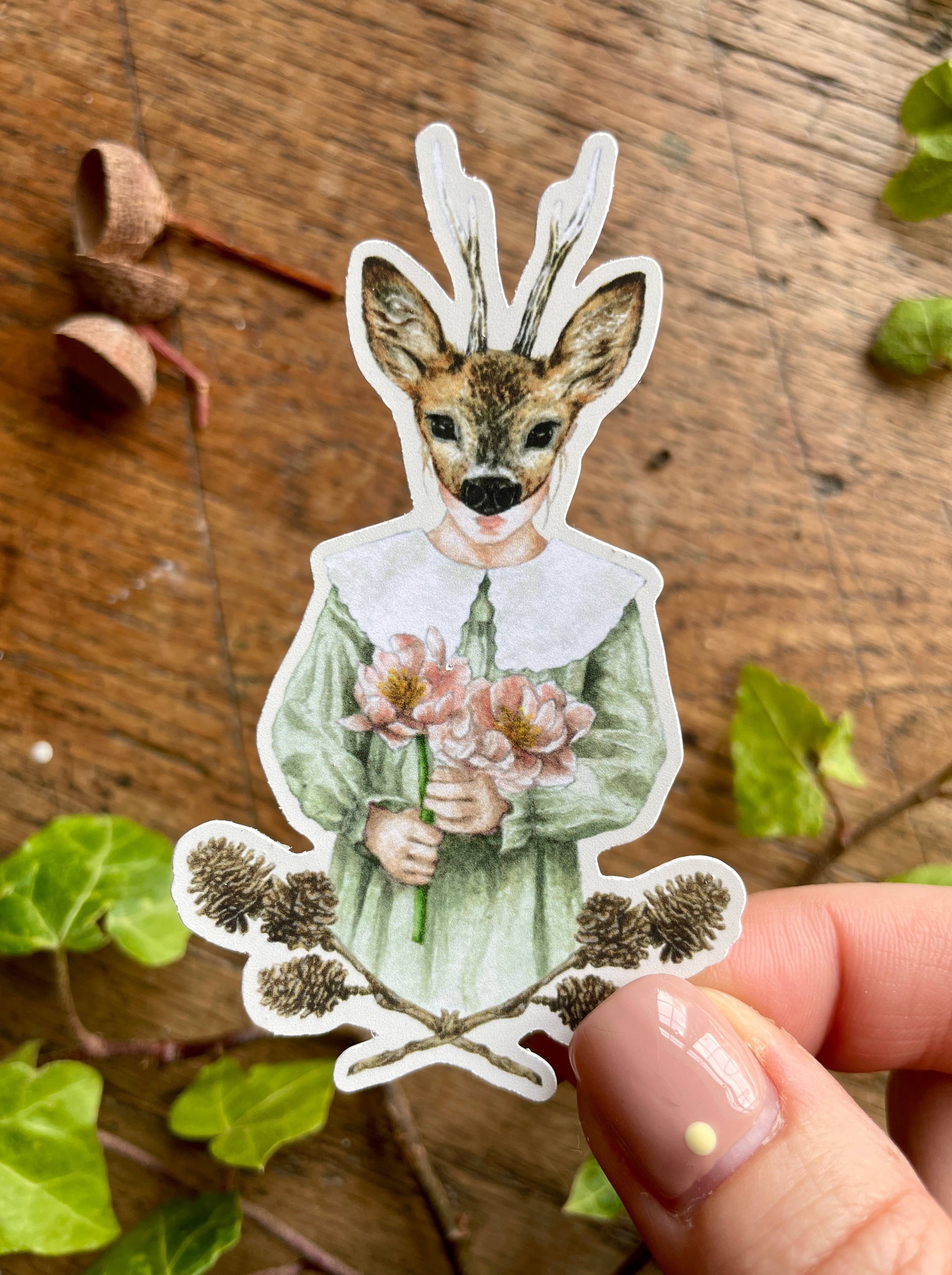 A vinyl watercolour sticker of a girl wearing a deer mask, dressed in a green dress with a fabulous lace collar and holding a bunch of pink flowers. 