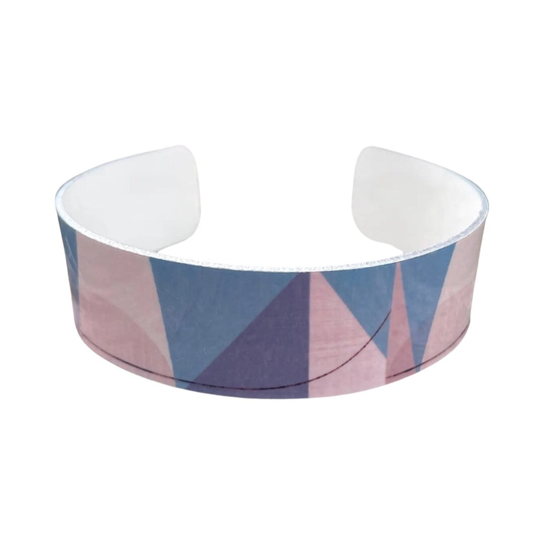 Front of narrow statement cuff bracelet featuring an abstract light blue, grey and white printed design.