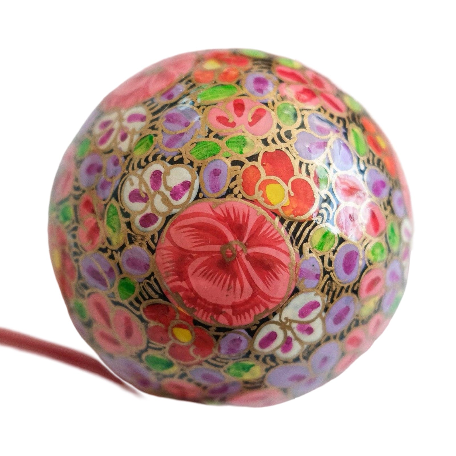 A round papier mache bauble in black with a lilac, pink, white and red floral design.