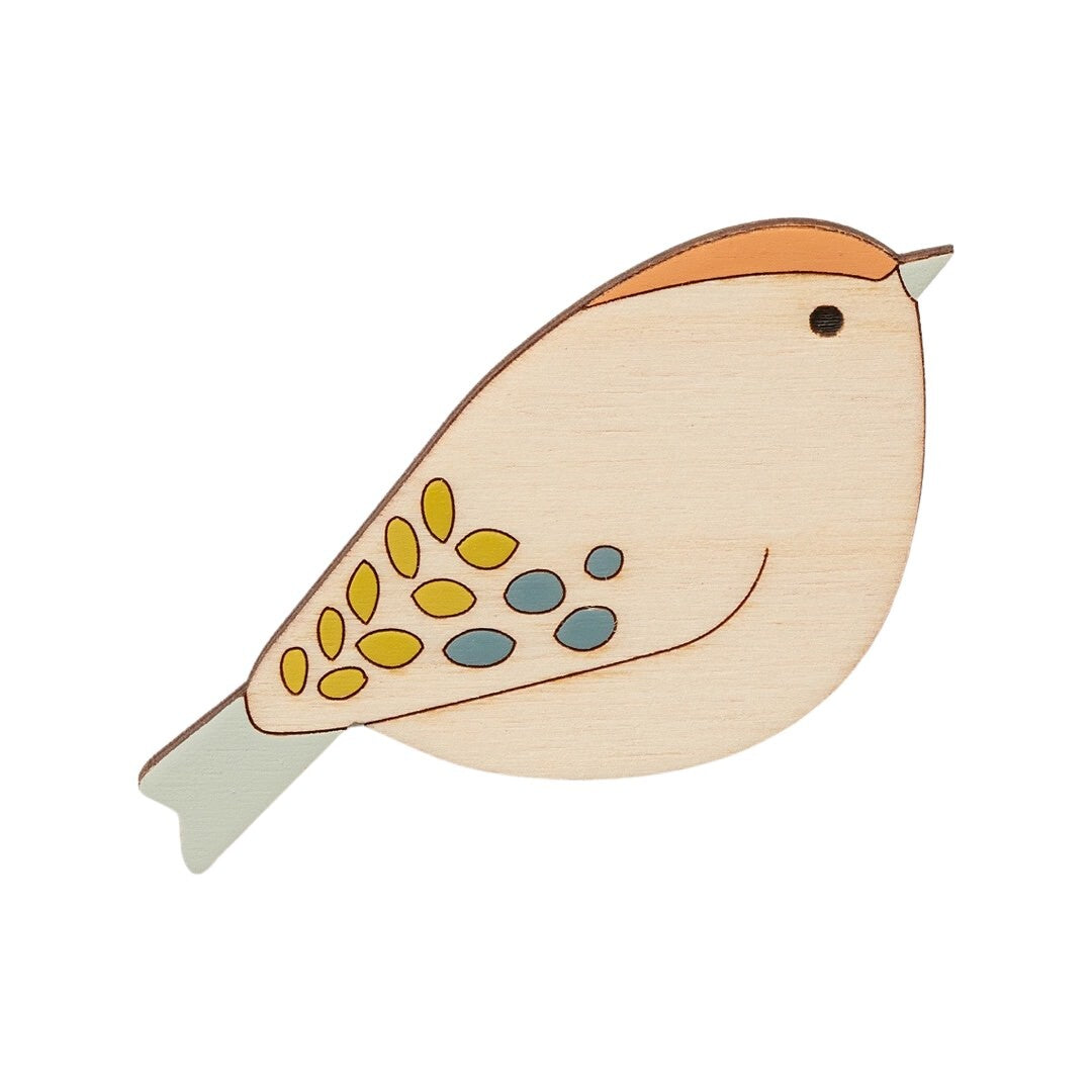 A goldcrest bird-shaped wooden brooch with an orange crest, and turquoise tail.