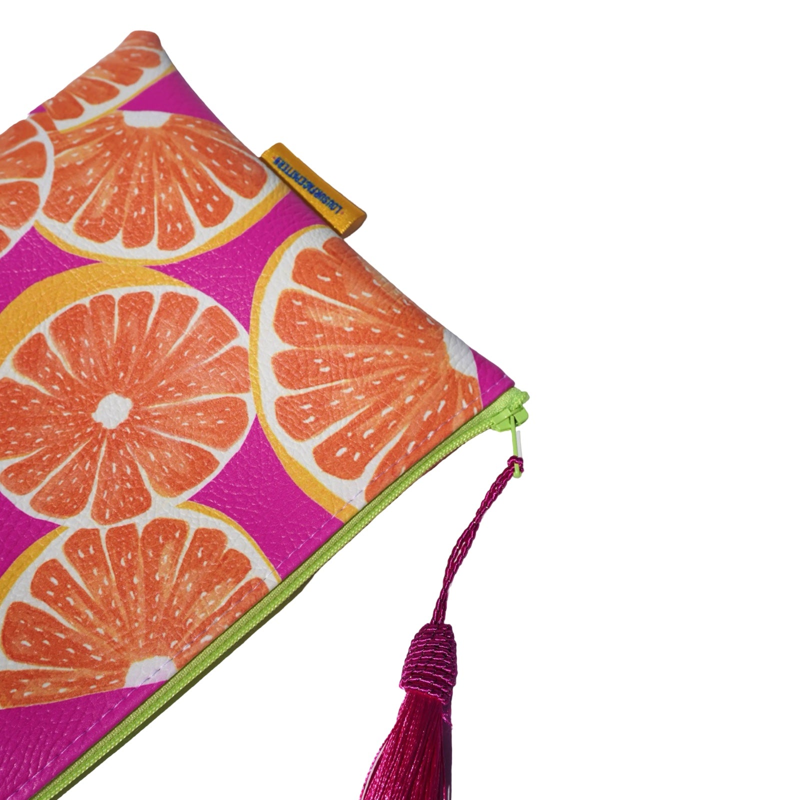 Vegan leather bag with a colourful grapefruit against a bright pink background, and the bag is finished with a fabulous matching tassel on the end of the zip. 