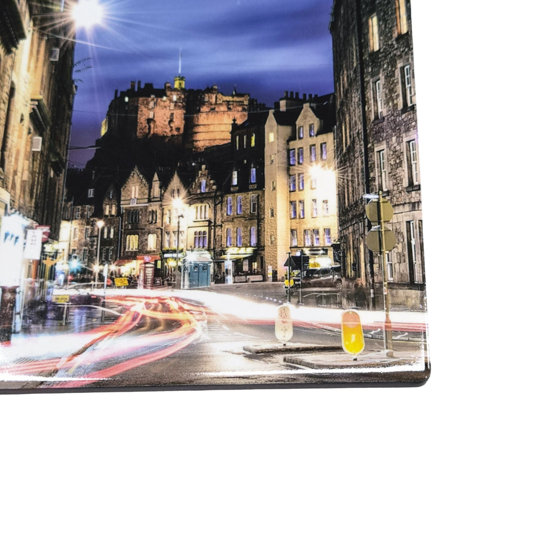City street at night with illuminated buildings and light trails on a ceramic coaster against a white background. 