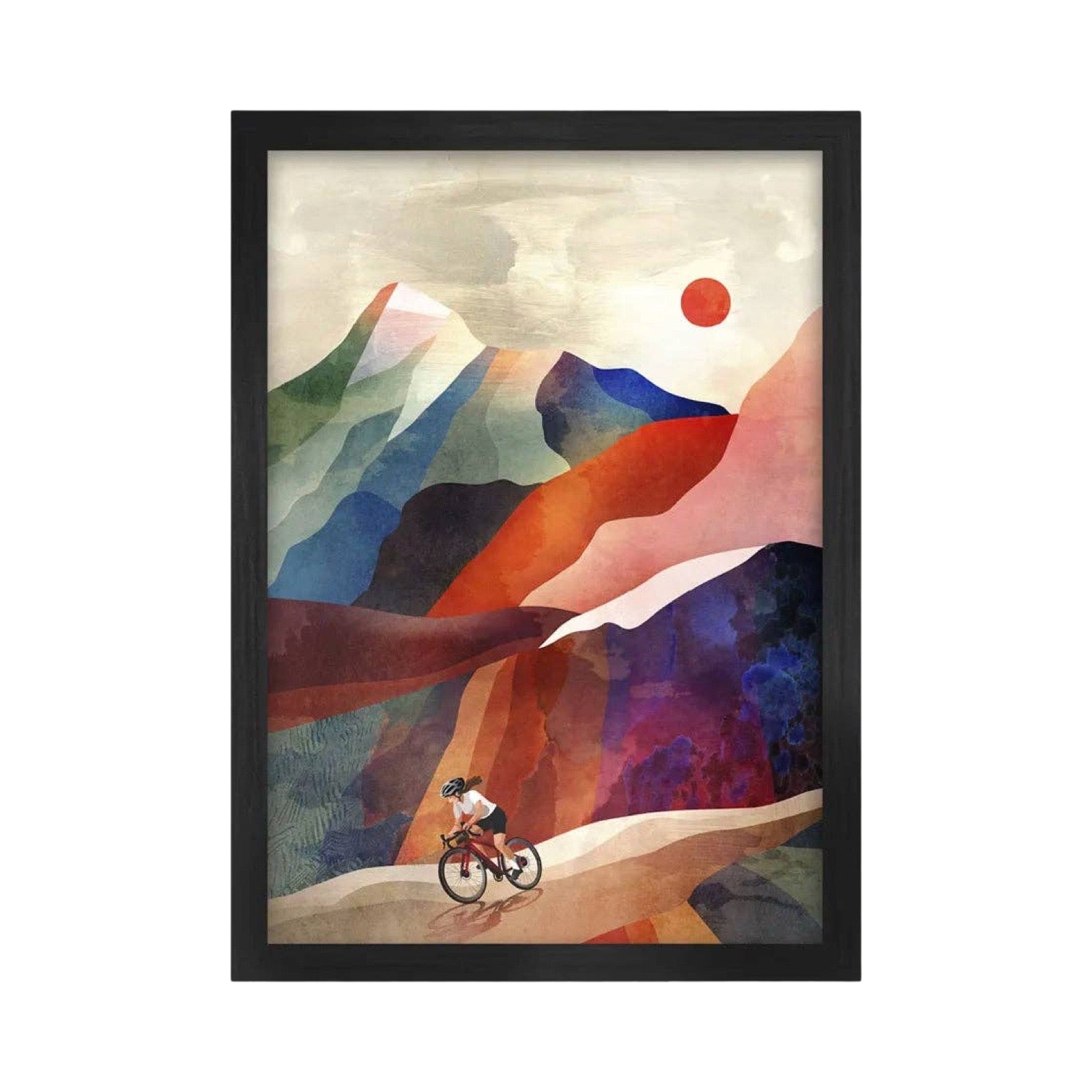 Framed art print featuring a stylized watercolor landscape with layered mountains in blue, purple, red, and beige tones, a small cyclist near the bottom, and a red sun in the sky. The print is enclosed in a black frame and shown against a plain white background.