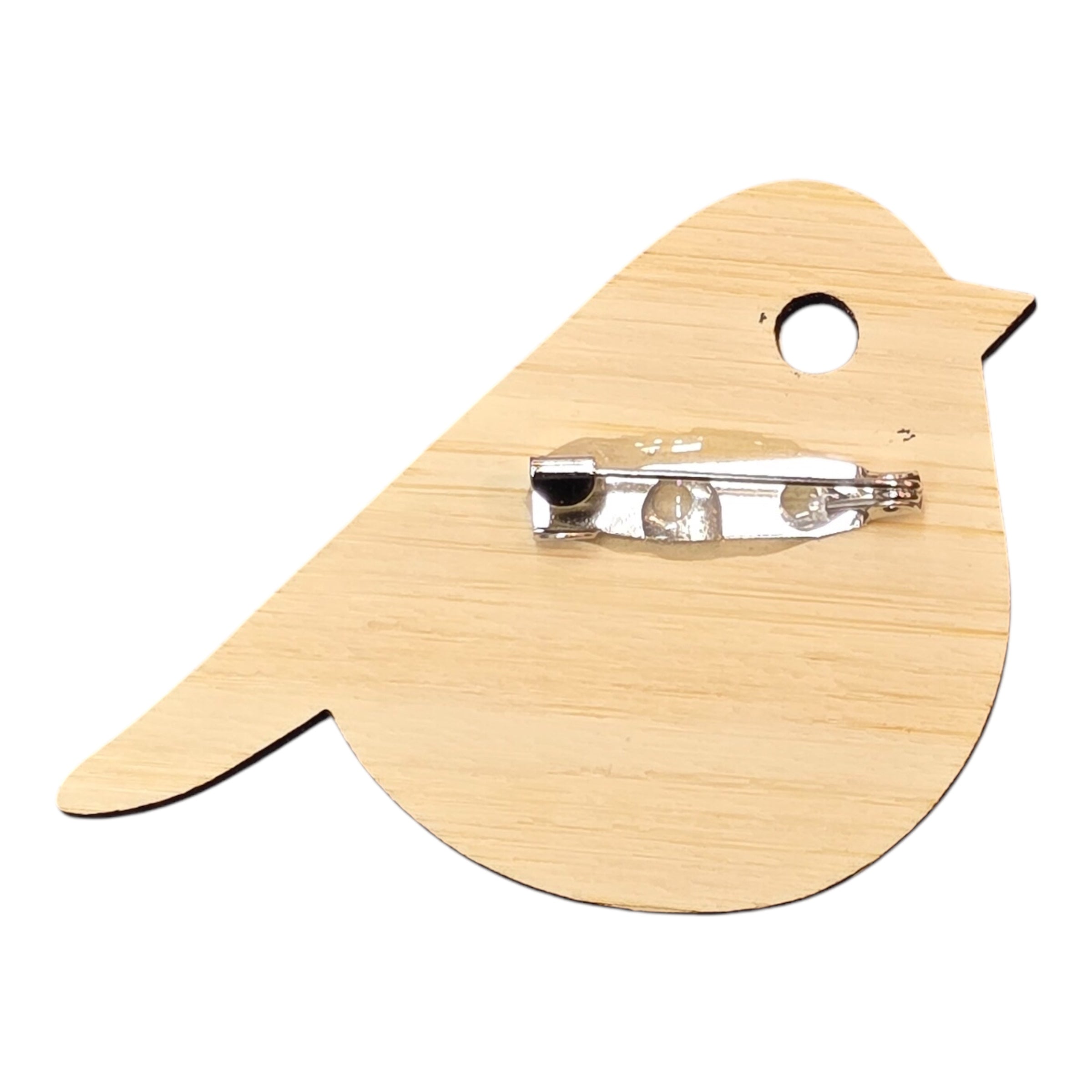 The back of a bird-shaped bamboo brooch with a silver coloured clasp.