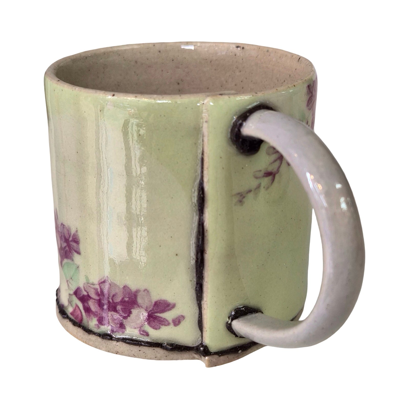 Ceramic mug with floral design and white handle on a white background.