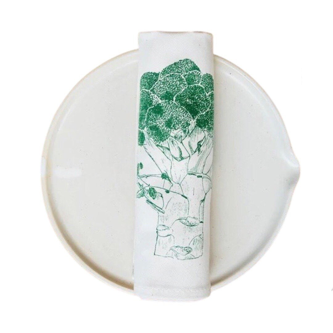 Cream cotton rolled napkin with a green broccoli.