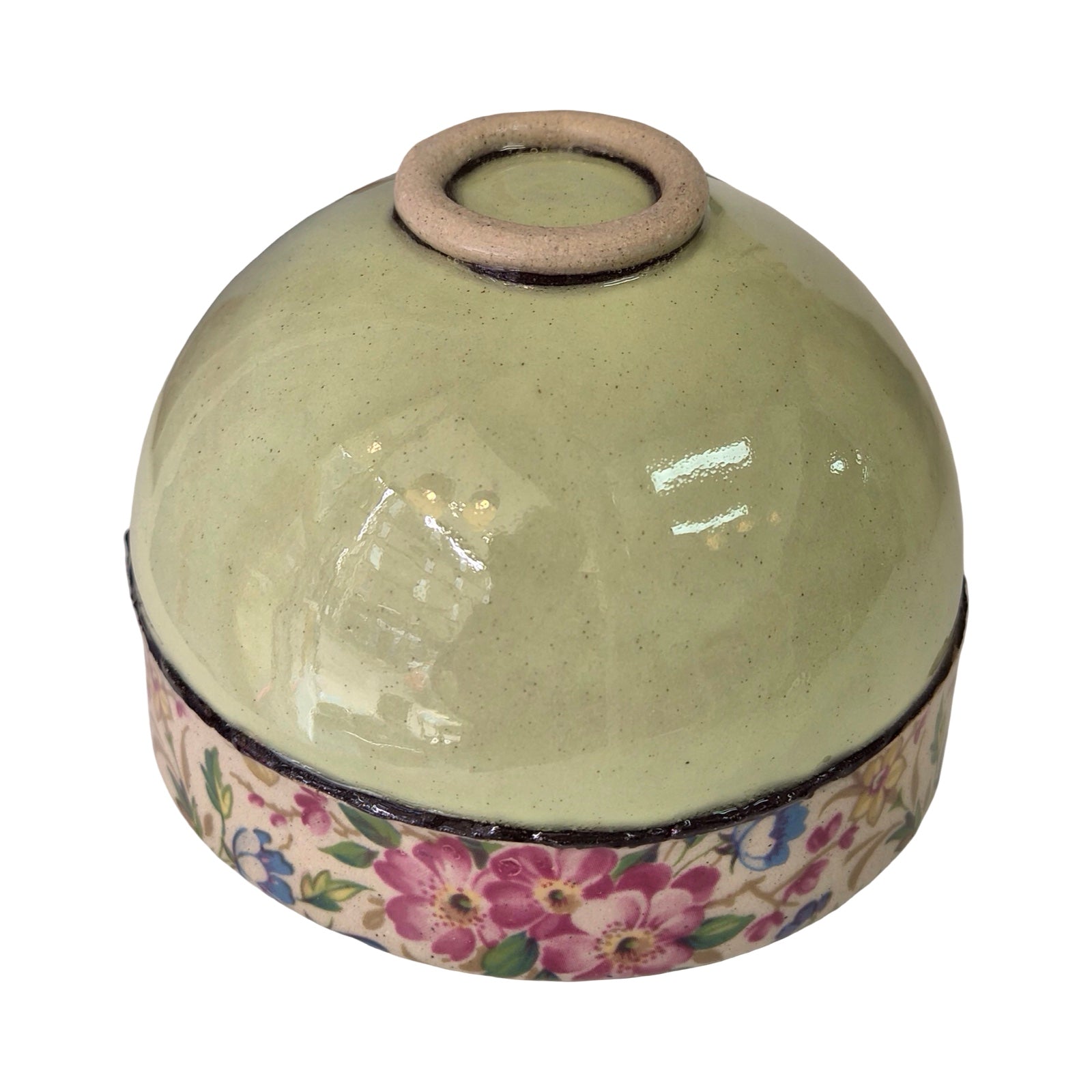 Upside down ceramic bowl with floral pattern on a white background.