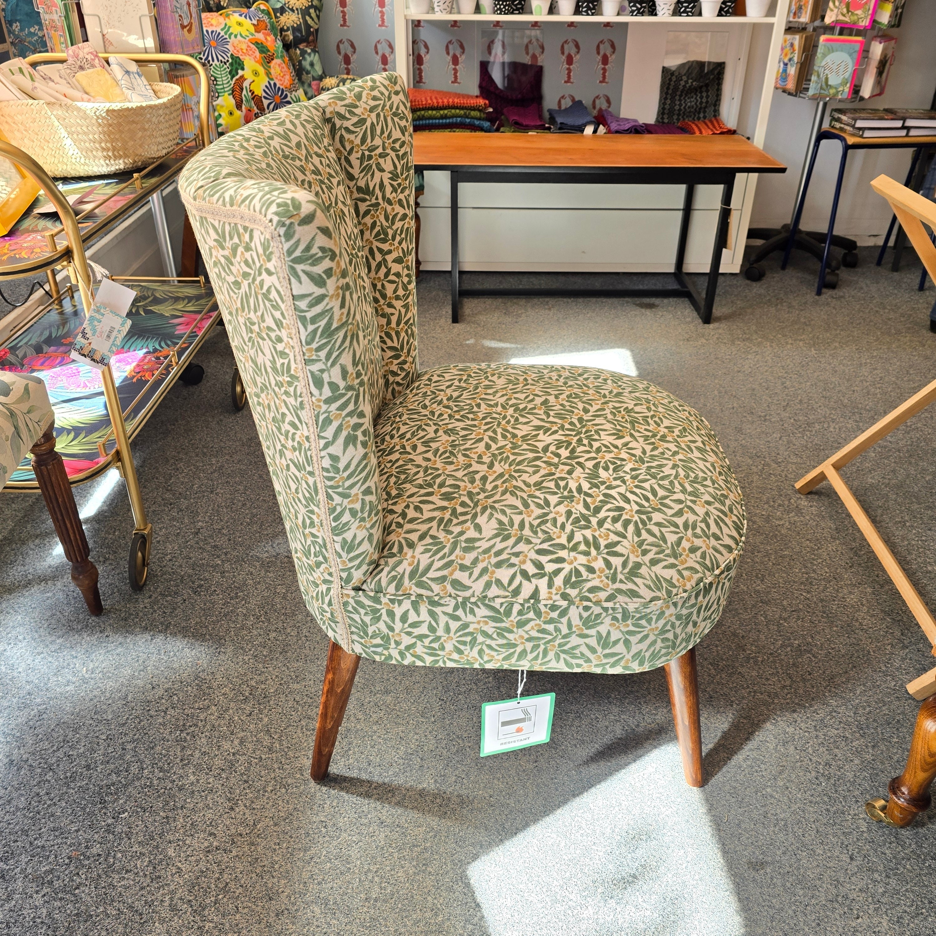 A fabulous cocktail chair covered in beautiful green foliage cotton fabric with mahogany legs. 