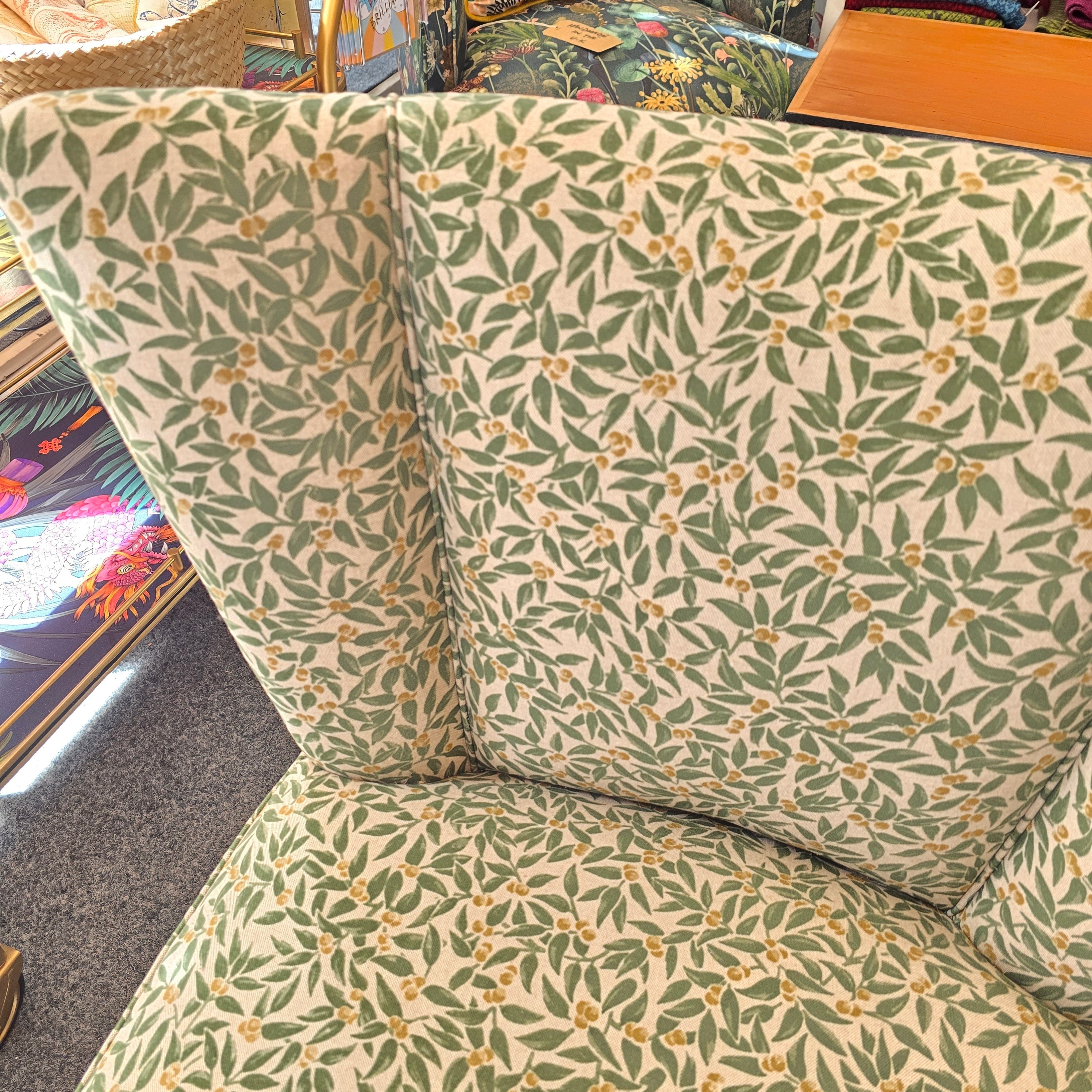 A fabulous cocktail chair covered in beautiful green foliage cotton fabric with mahogany legs. 