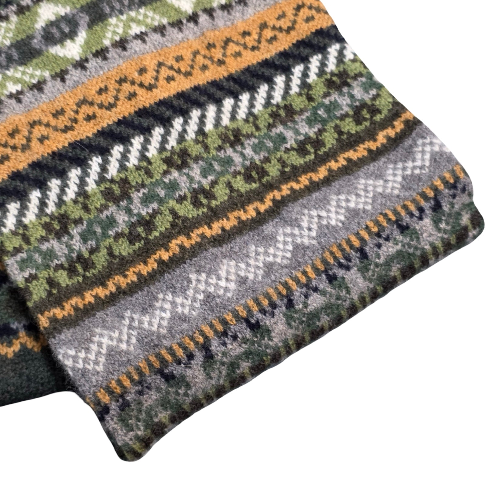 Knitted fabric with a pattern of green, gray, and orange on a white background.