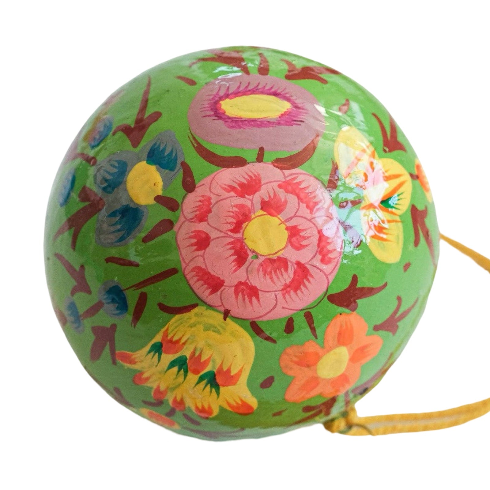 A round papier mache bauble in green with a pink, yellow, orange and blue floral design.