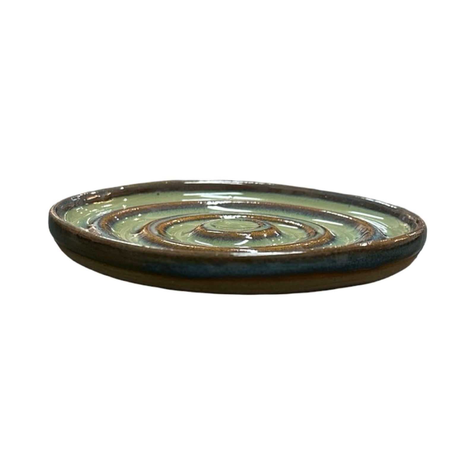 Ceramic green dish with a spiral design on a white background.
