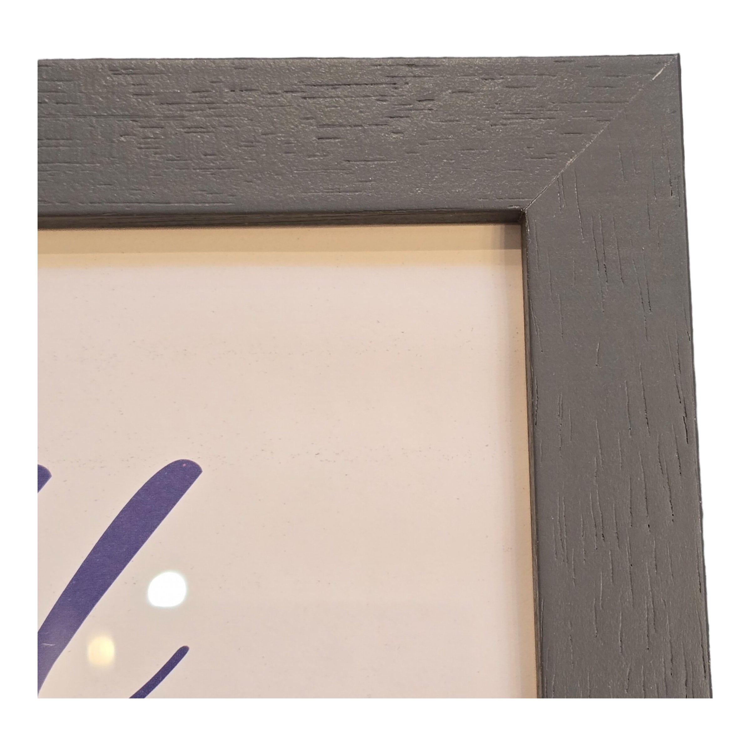 The corner detail of a dark grey picture frame