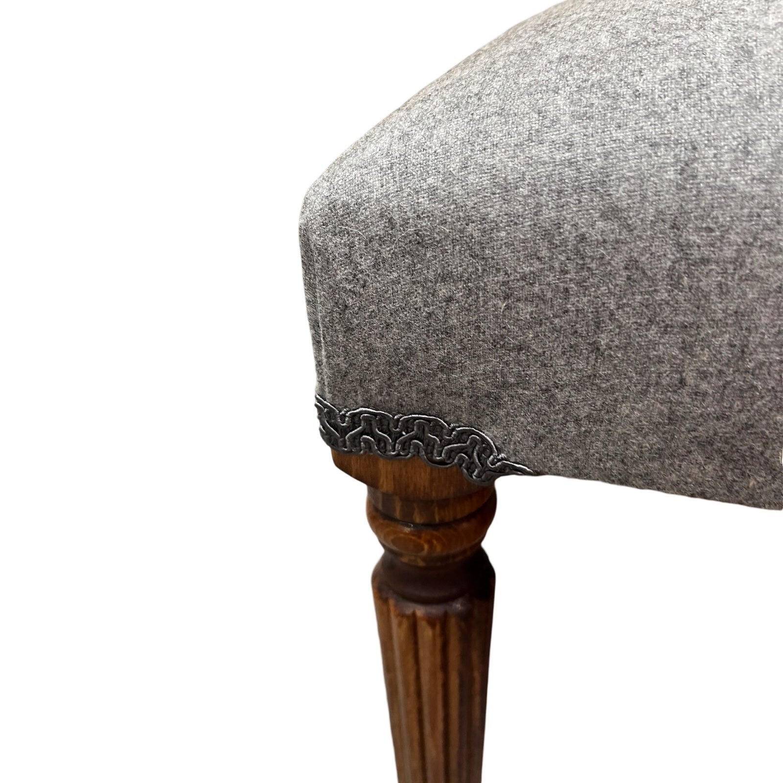 A rectangular grey wool bench with mahogany legs, upholstered and hand-crafted.