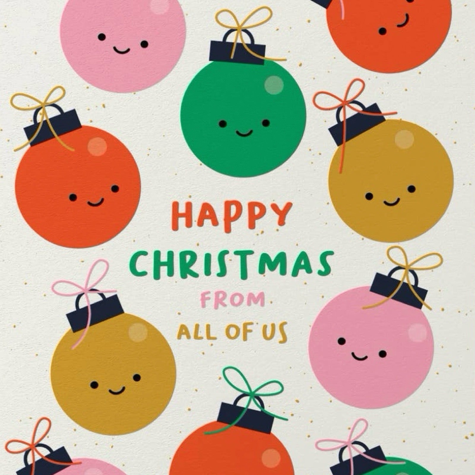 A festive Christmas greeting card design with cute, smiling ornament illustrations in pink, green, orange, and gold around the words “HAPPY CHRISTMAS FROM ALL OF US” on a light cream background with subtle gold speckles.